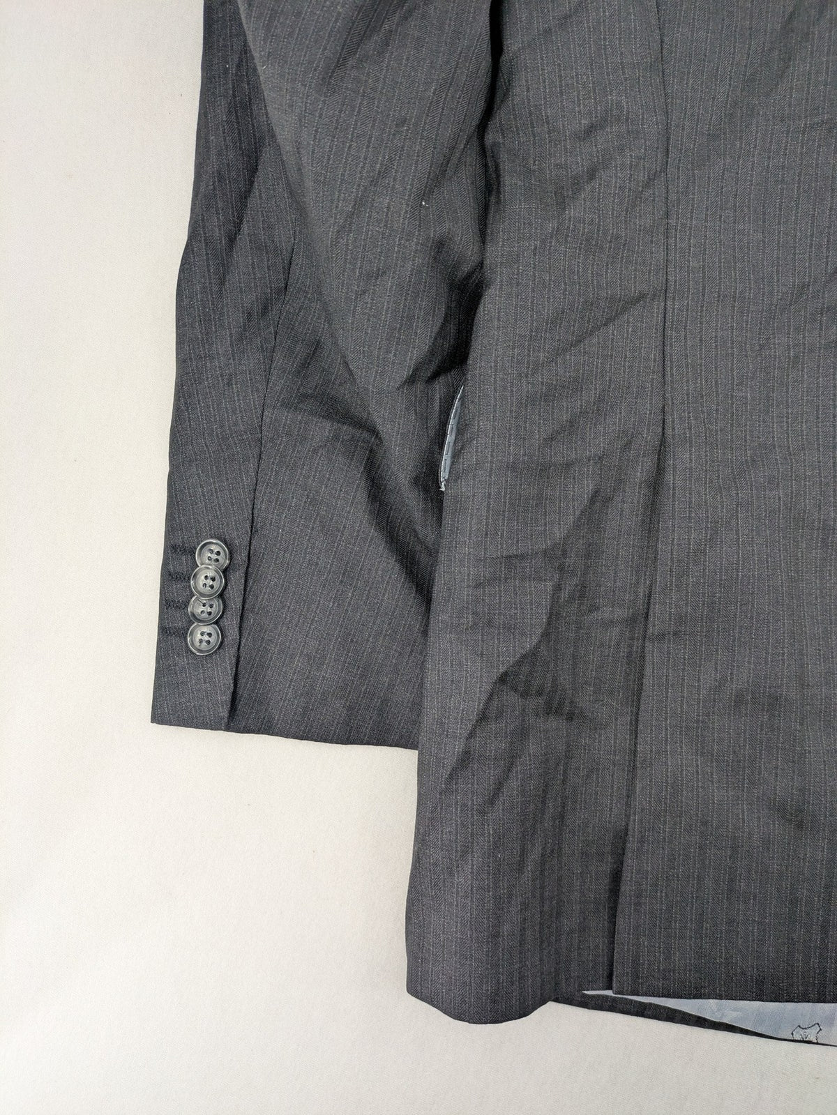 Desch grey blazer with dark grey pinstripe pattern, satin lining, and tailored design.