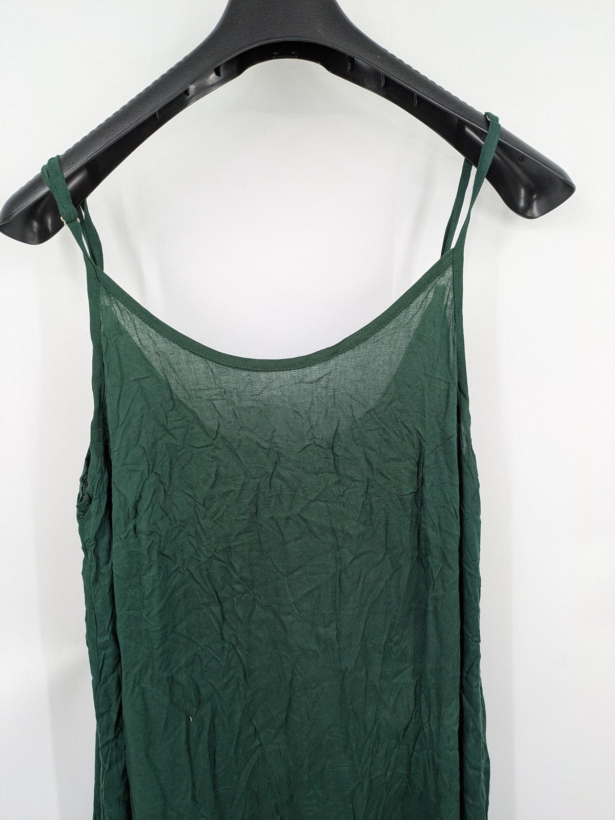 Boho green maxi dress with floral embroidery along tiered hem and adjustable spaghetti straps.