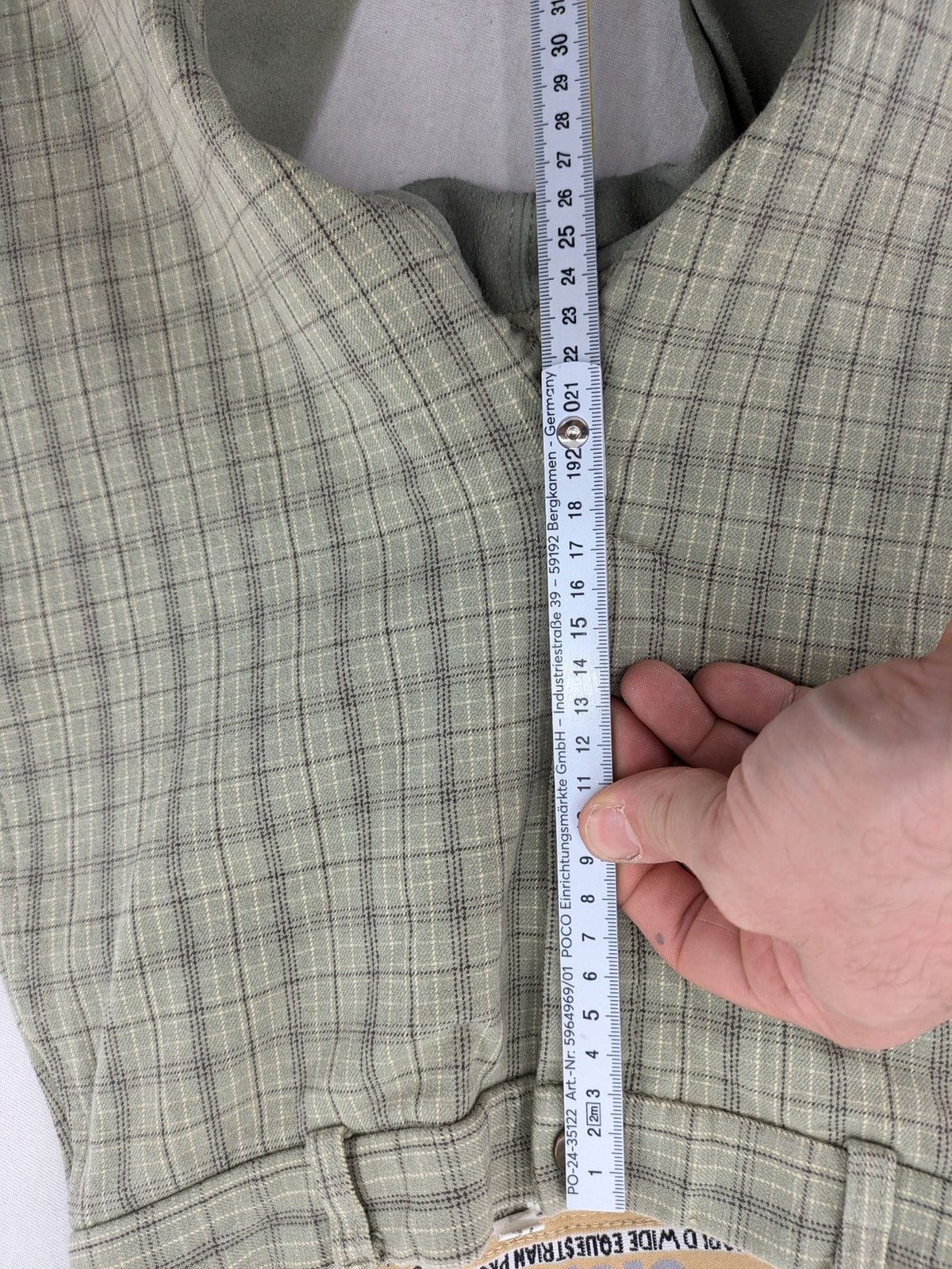 Jodhpur beige and grey riding pants with green check pattern and knee patches.