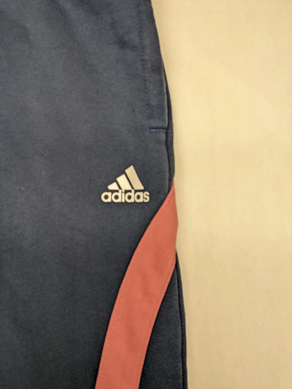 Adidas grey joggers with pink stripes and iconic logo on thigh.