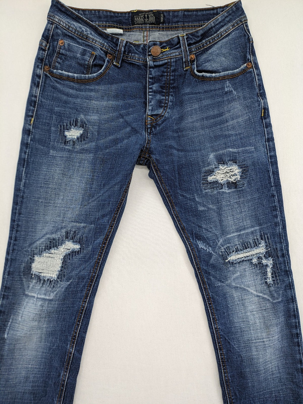 Soda blue straight jeans with distressed rips and button fly, cotton blend material.