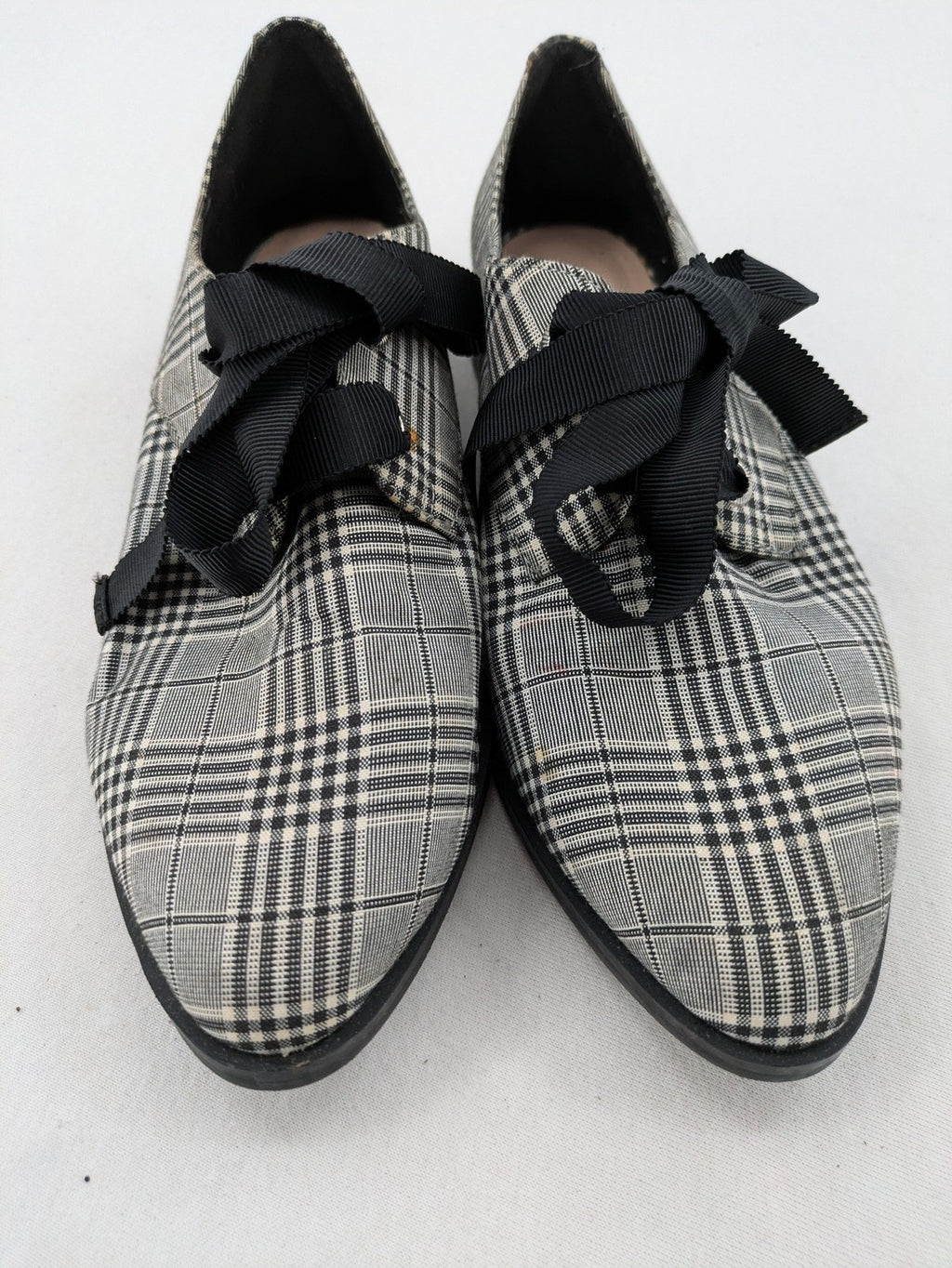 ALDO black and white checkered loafers with decorative bow detail and pointed toe.