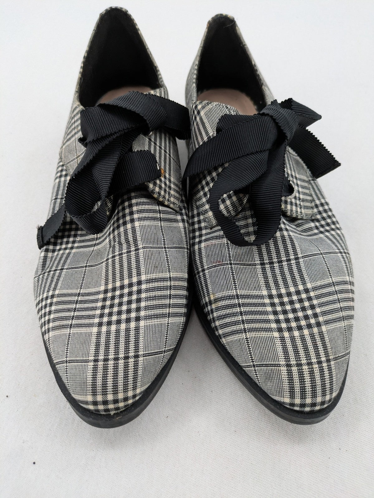 ALDO black and white checkered loafers with decorative bow detail and pointed toe.