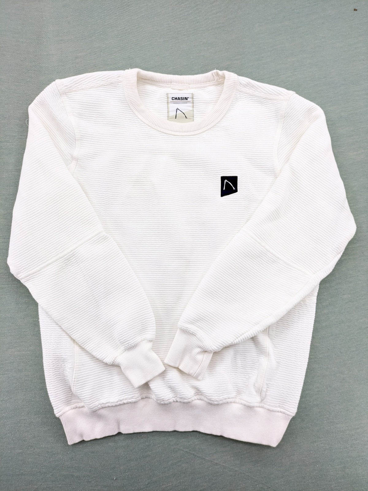 CHASIN' grey and white turtle neck jumper with horizontal ribbed texture and logo patch.