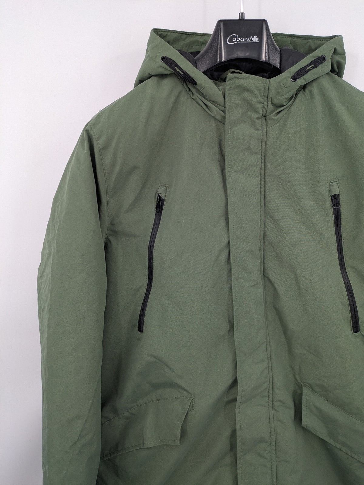 Bad Choices green parka coat with reflective details and logo patch on sleeve.