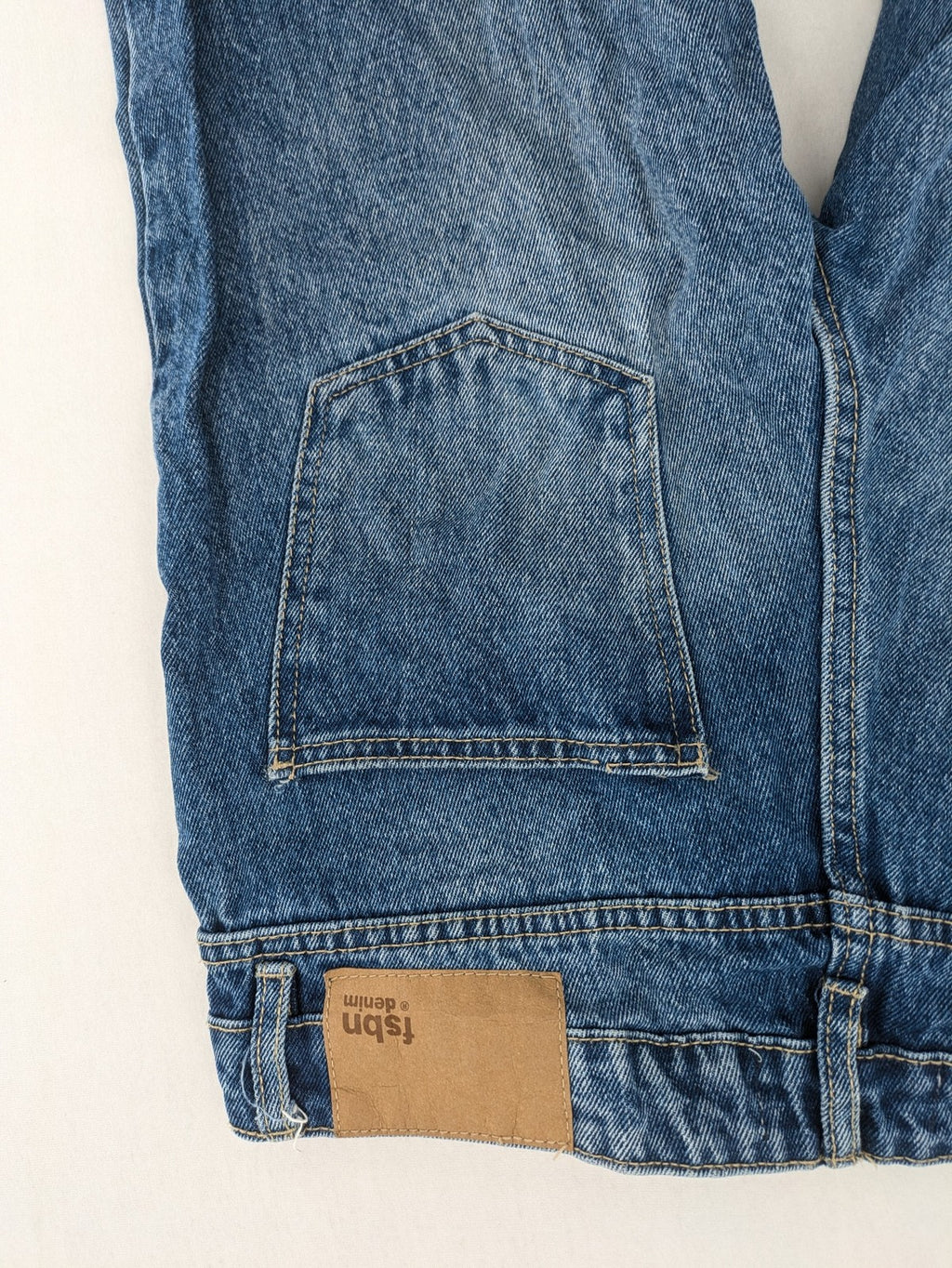 FSBN blue straight jeans with distressed knee rips and classic button fly.