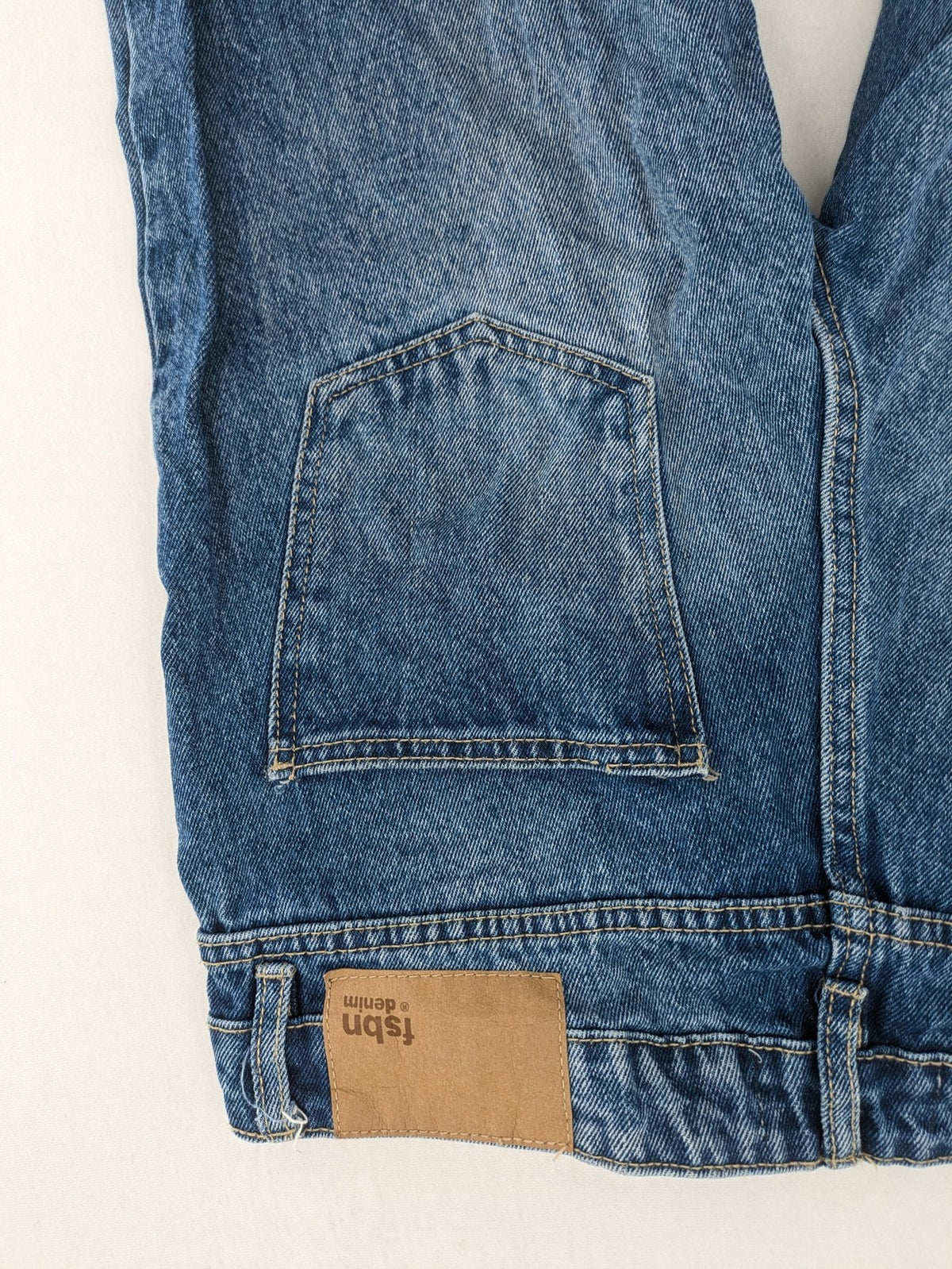 FSBN blue straight jeans with distressed knee rips and classic button fly.