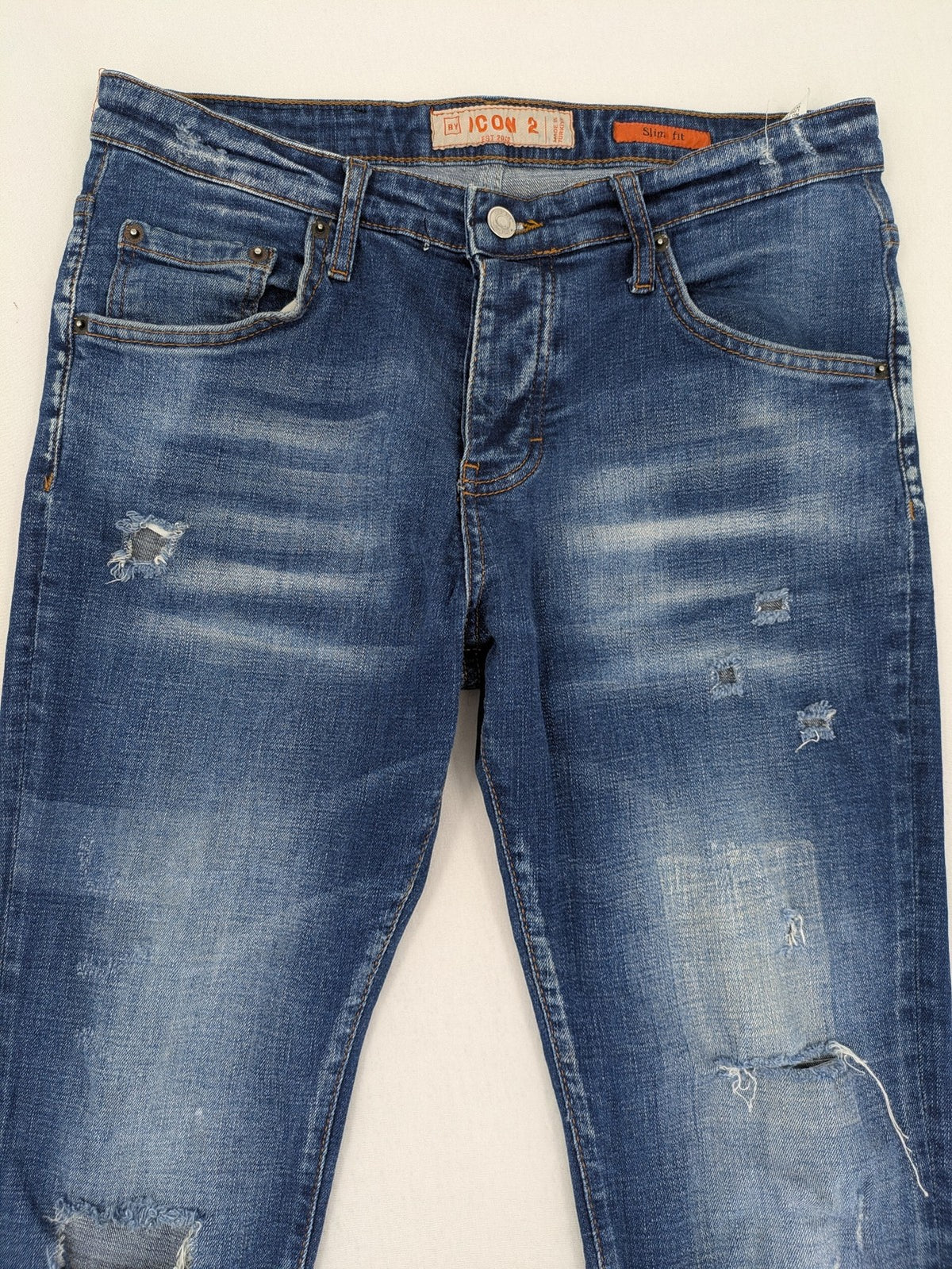 ICON 2 blue slim fit jeans distressed stretch denim with button fly and faded details.