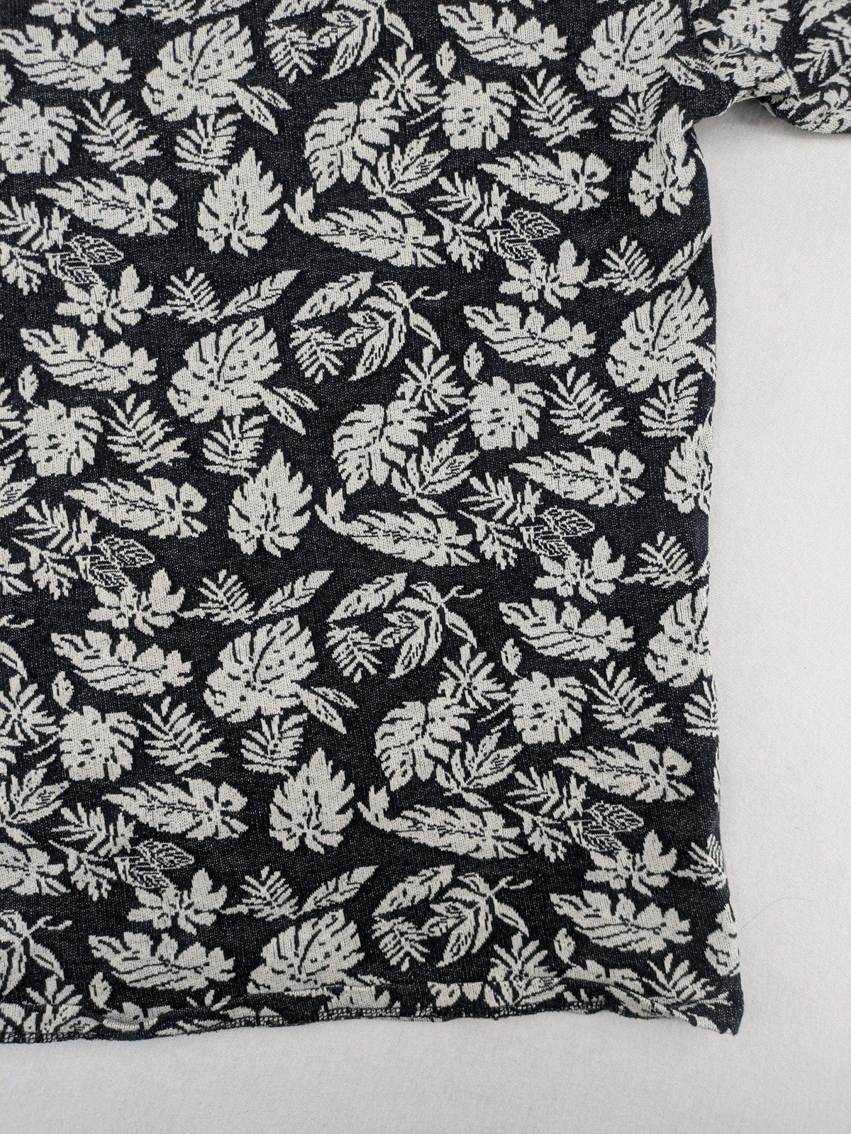 Zara Man black and white t-shirt with allover leaf print and textured knit fabric.