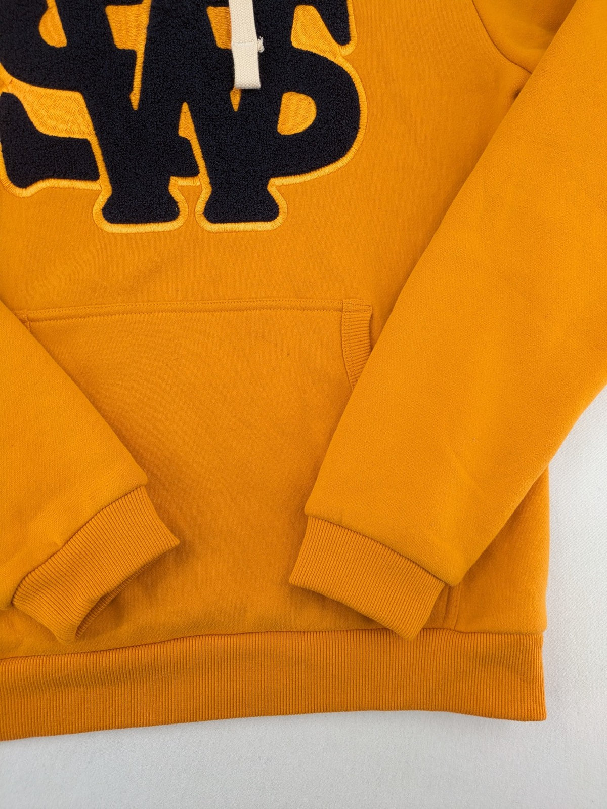 Superdry orange turtle neck jumper with textured logo patch and number 7 detail.