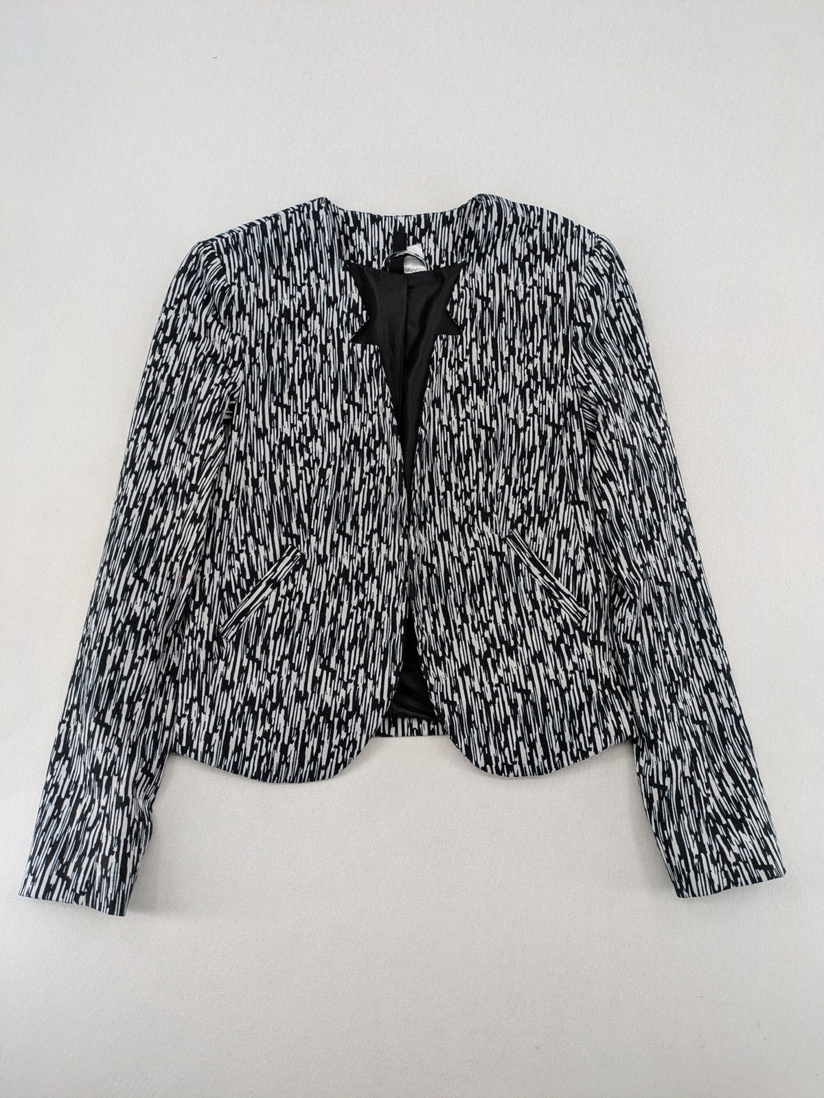 H&M Divided black and white patterned blazer with open front and two front pockets.