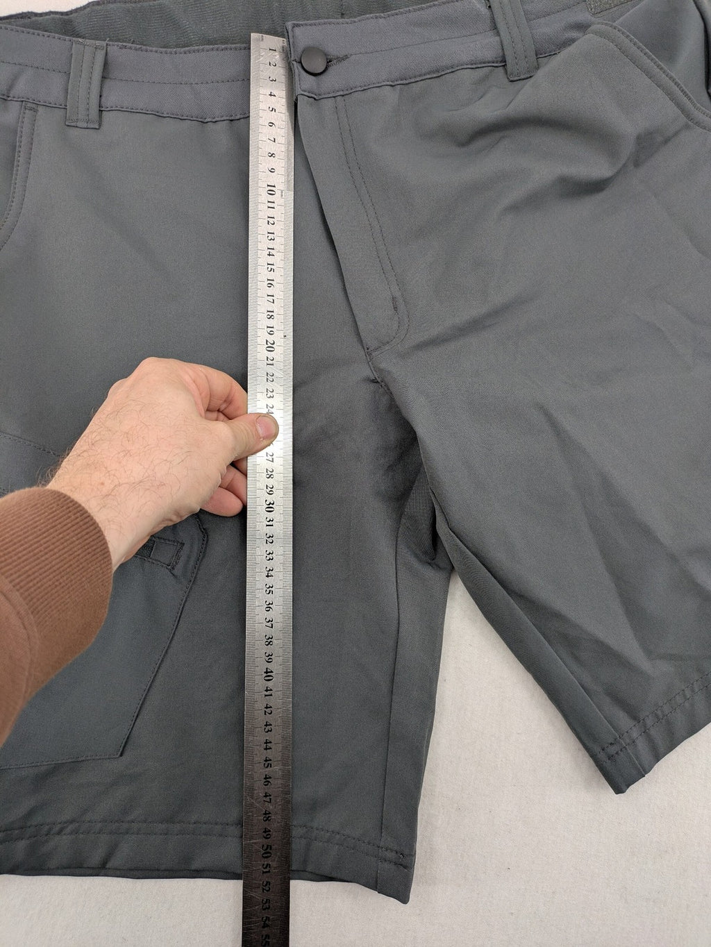 Outdoor grey functional shorts with adjustable velcro waistband and zippered leg pocket.