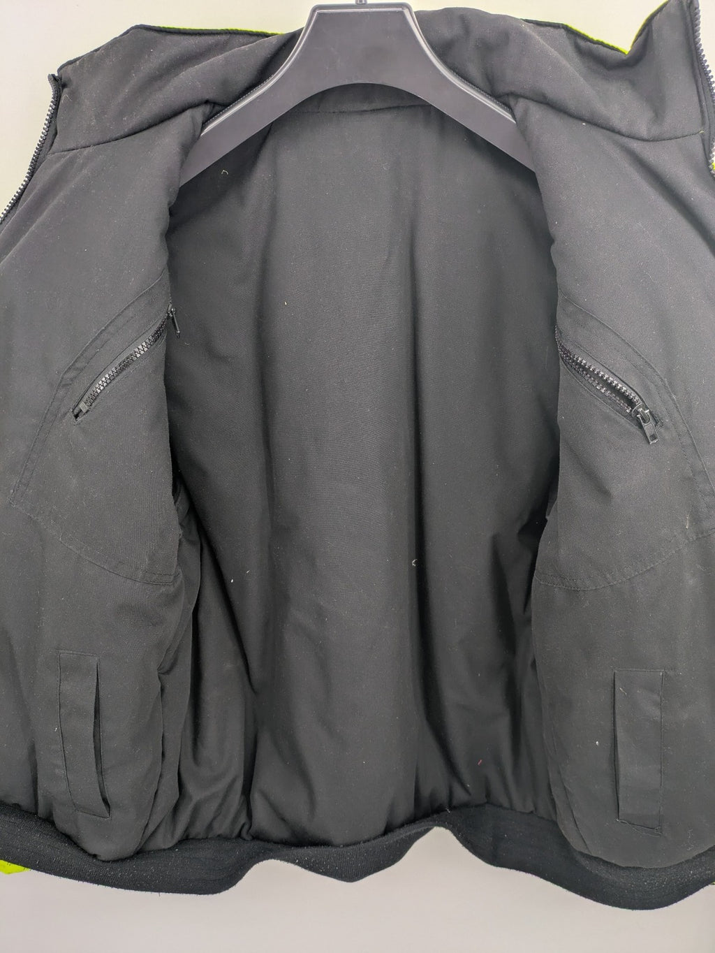 Hüren OHG grey and neon yellow safety jacket with reflective stripes and zippered arm pocket.