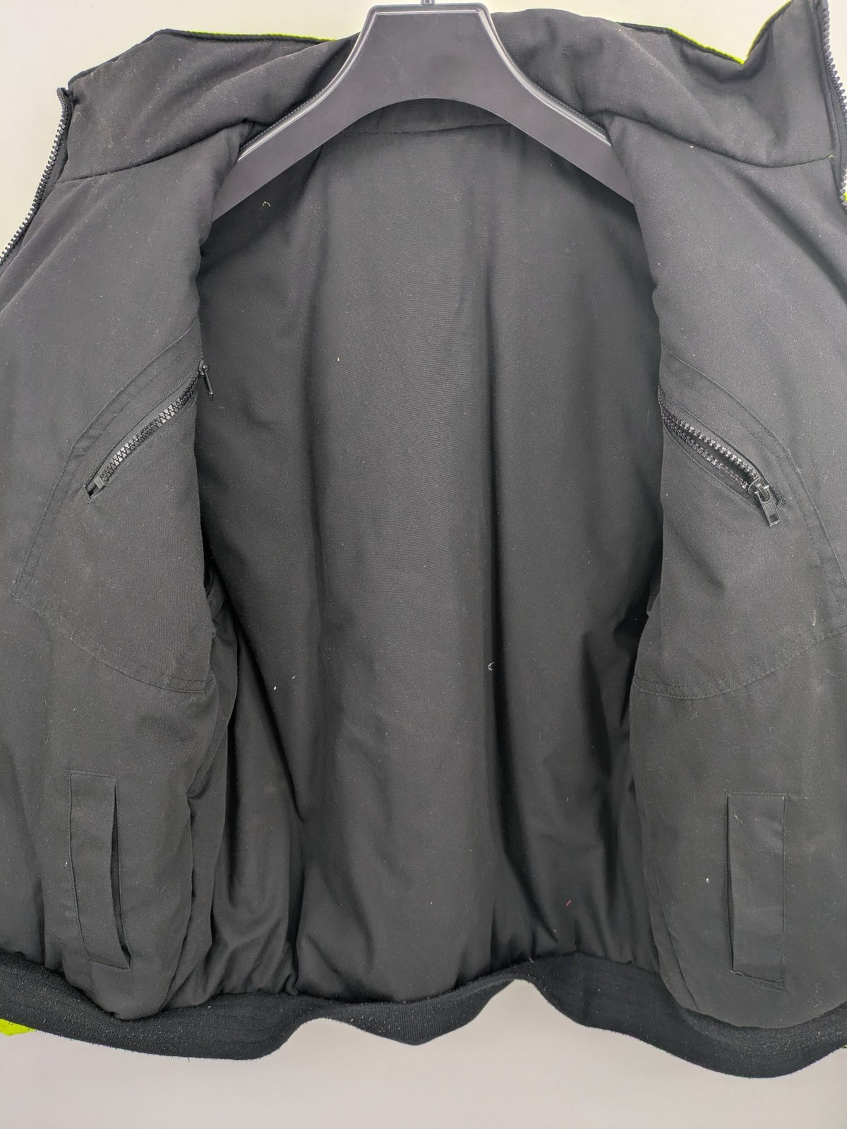 Hüren OHG grey and neon yellow safety jacket with reflective stripes and zippered arm pocket.