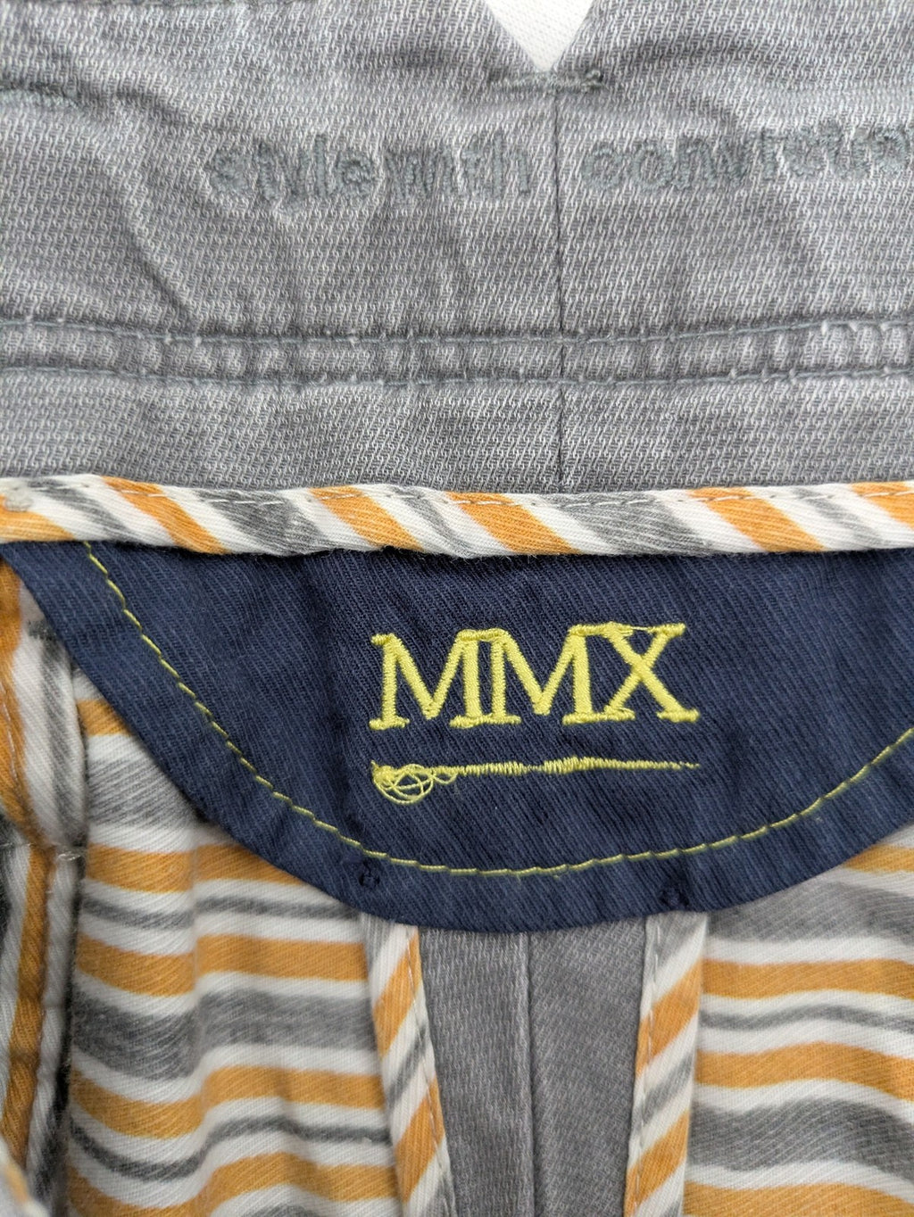 MMX grey chino pants with patterned interior lining and contrasting waistband, made from organic cotton.