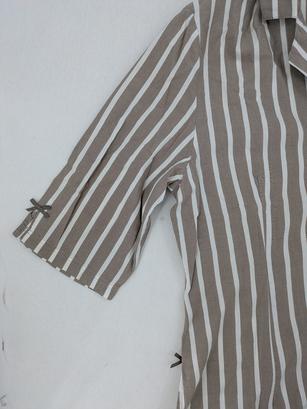Body Sunday beige and white striped loungewear top with bow accents and button placket.