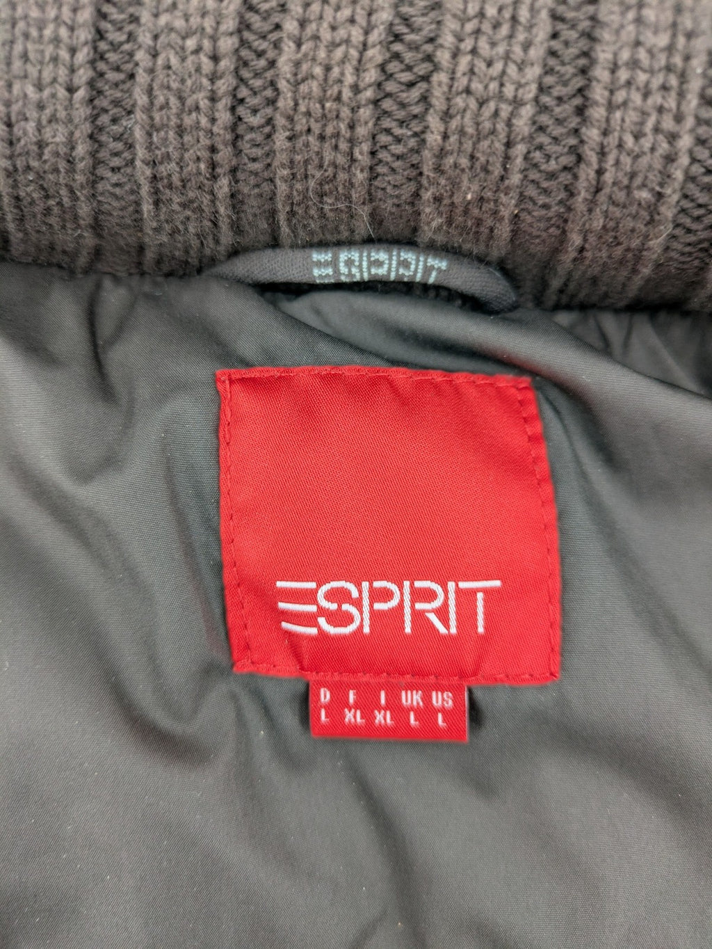 Esprit brown puffer vest with high ribbed collar and zip button closure.