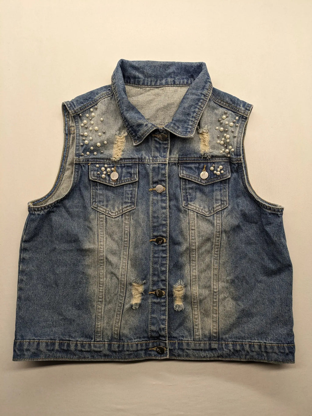 Damen Jeansjacke blau ärmellos mit Perlenverzierung, distressed Details und Knopfleiste.