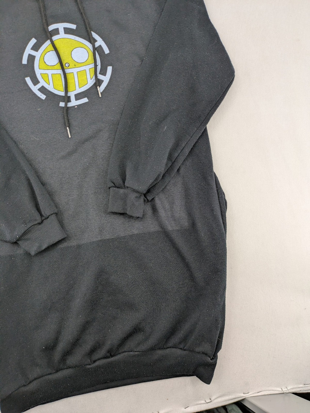 One Piece long hoodie black featuring Trafalgar Law's Jolly-Roger logo and drawstring hood.