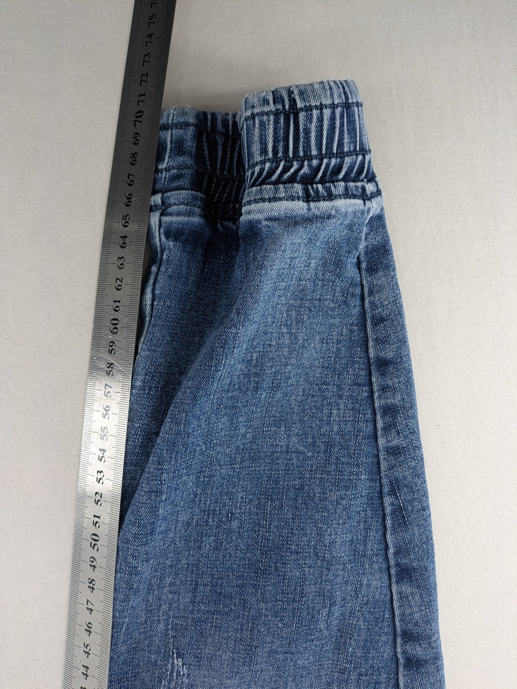 FN.G blue straight jeans with AC/DC patch, smiley face, and elastic jogger cuffs.