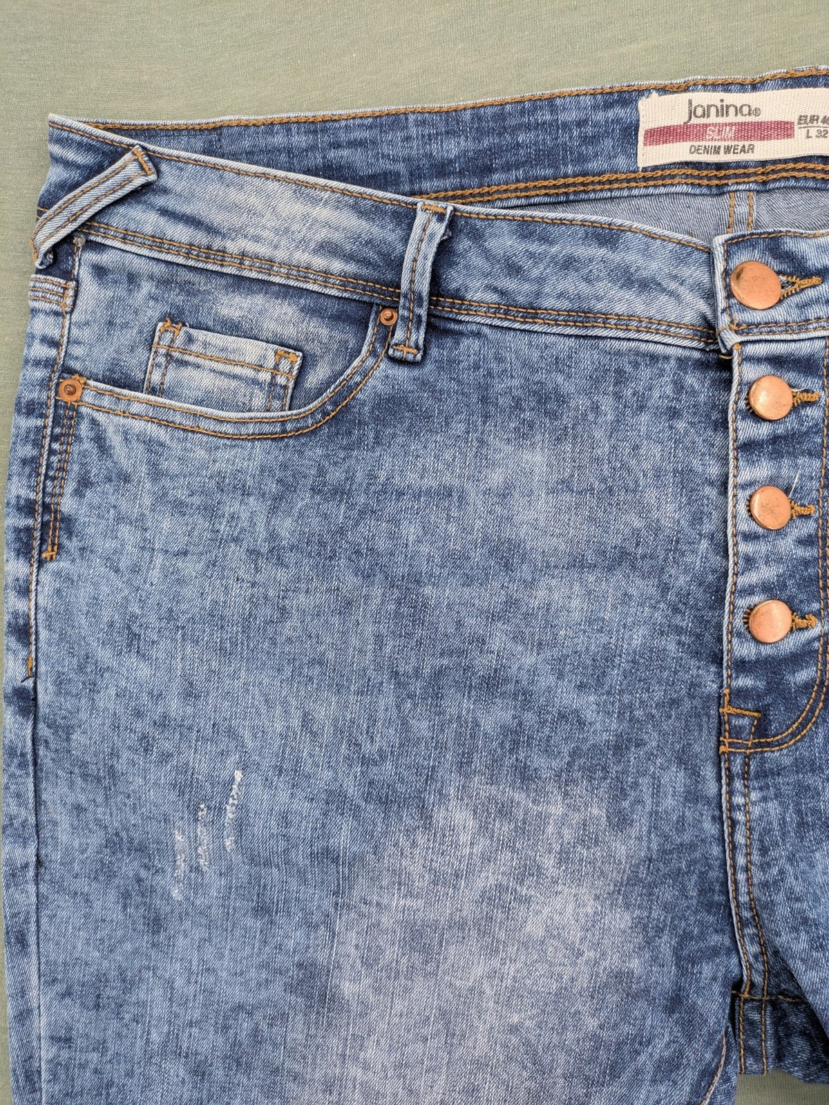 Janina blue slim fit jeans with acid wash, destroyed details, and button fly.
