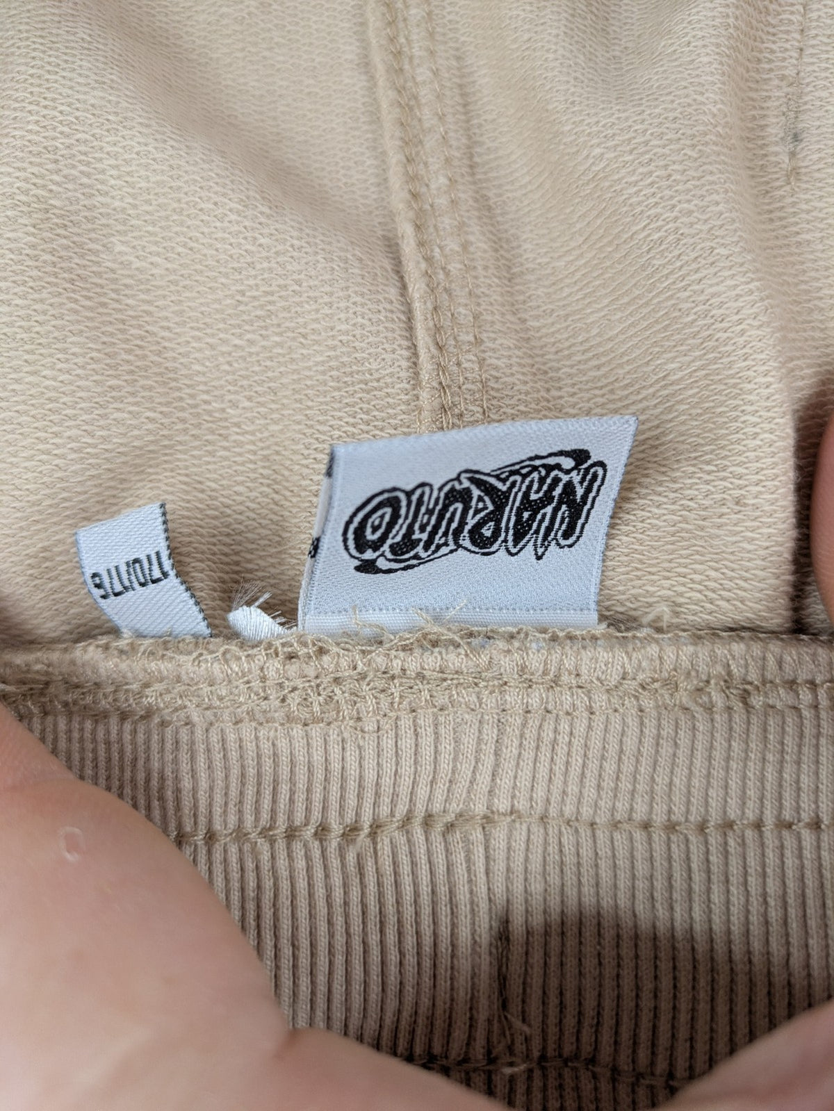 Naruto Shippuden beige joggers featuring Naruto Uzumaki graphic and logo print.