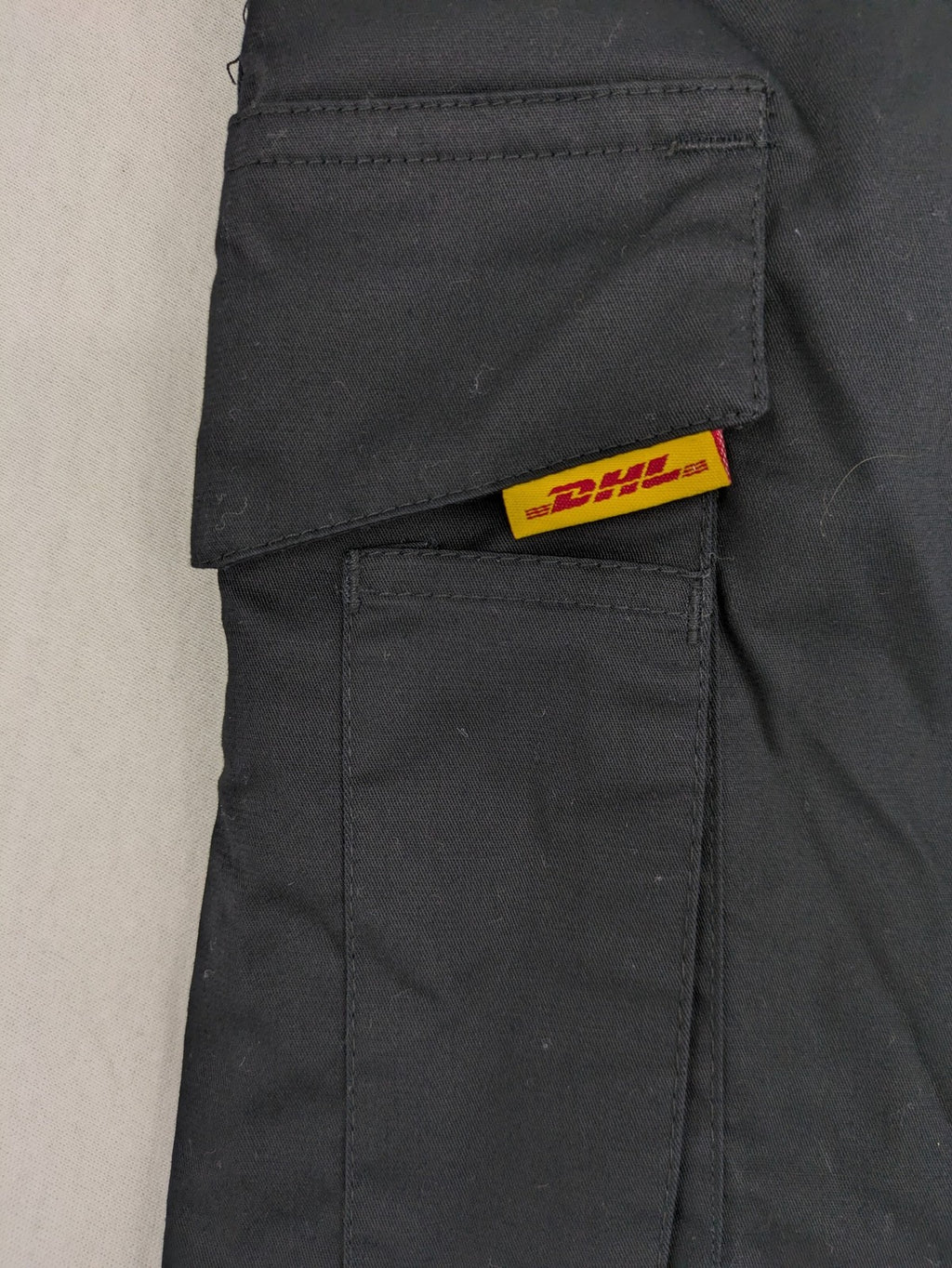 DHL grey cargo pants with iconic logo and multiple pockets, made from stretch cotton.