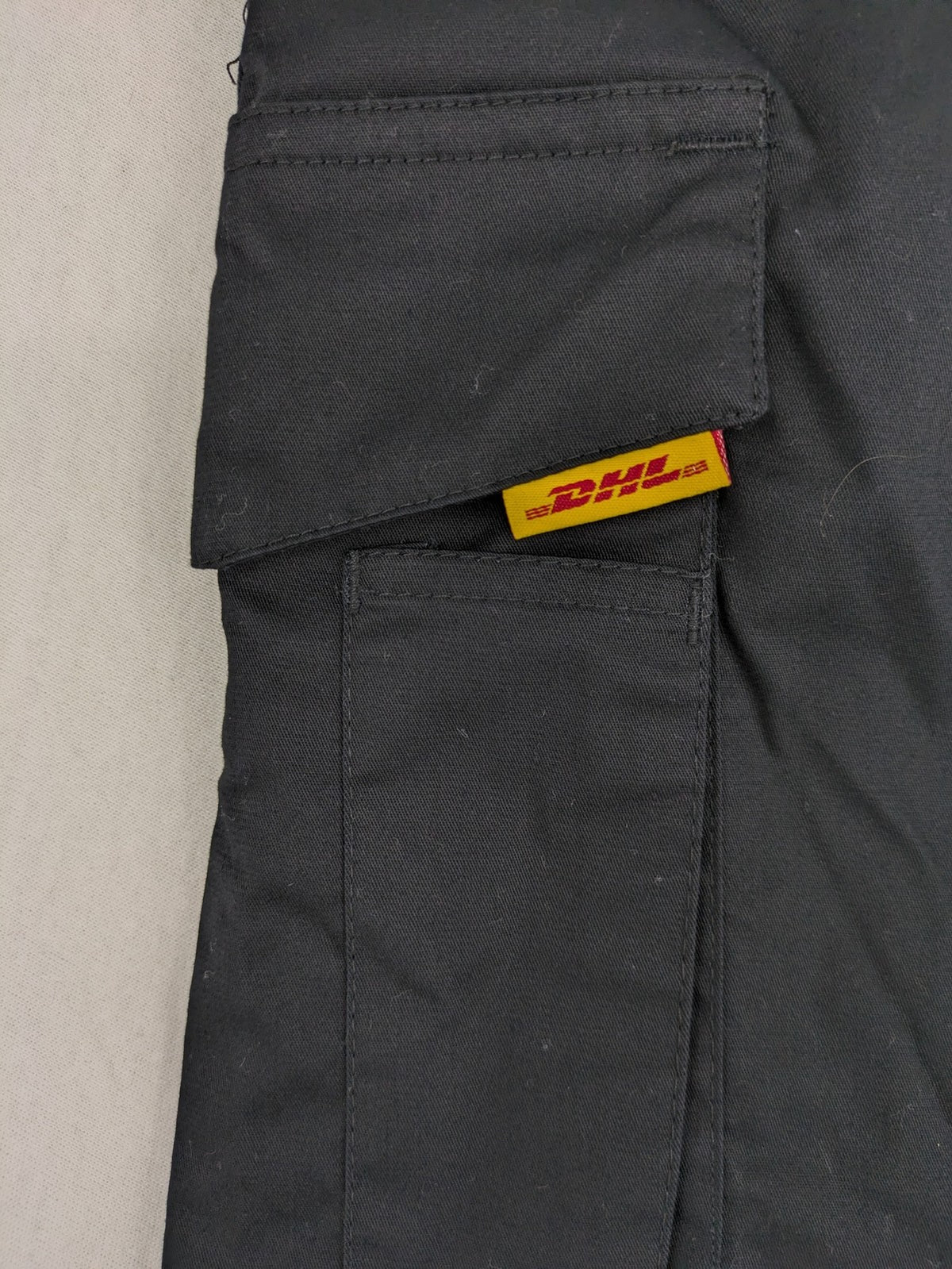 DHL grey cargo pants with iconic logo and multiple pockets, made from stretch cotton.