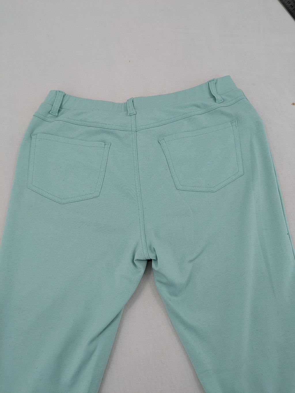 Dito green treggings with pull-on design, front pockets, and belt loops.