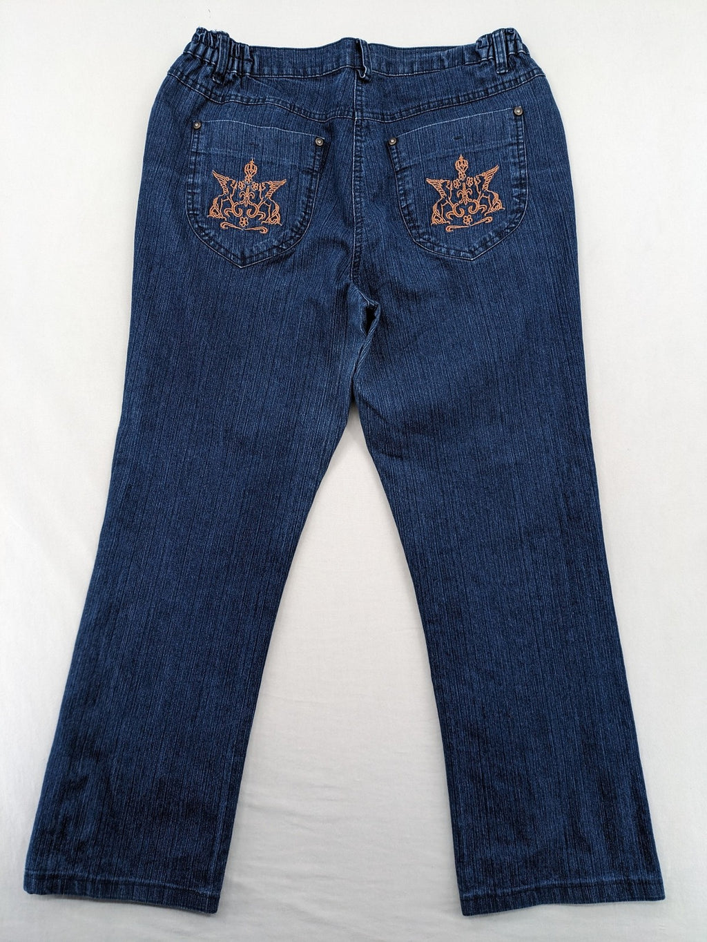 Outfit blue straight jeans with elastic waistband and embroidered crown-wing emblem on pockets.