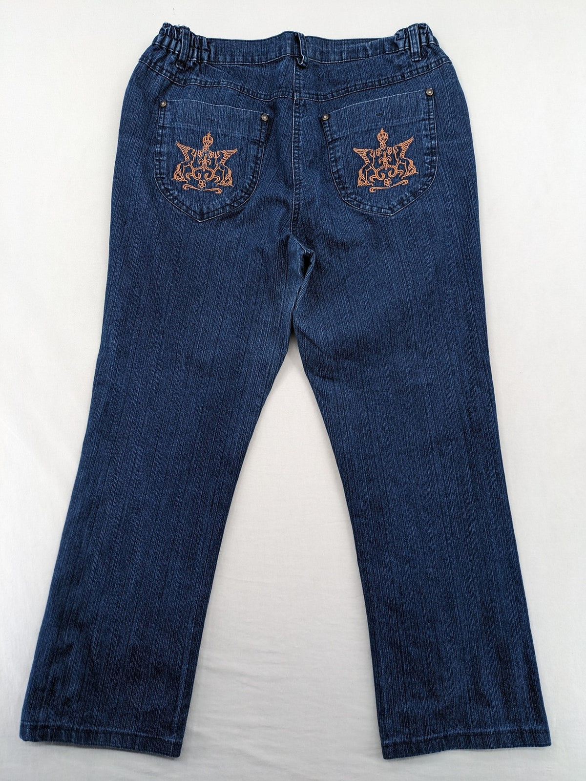 Outfit blue straight jeans with elastic waistband and embroidered crown-wing emblem on pockets.