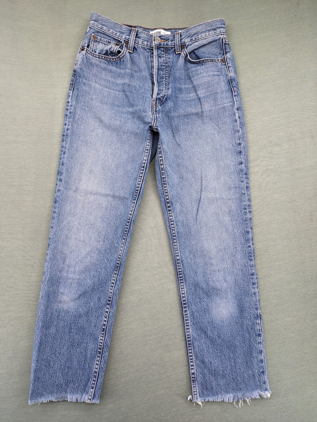 Re/Done blue straight jeans high rise with button fly and raw hem detail.