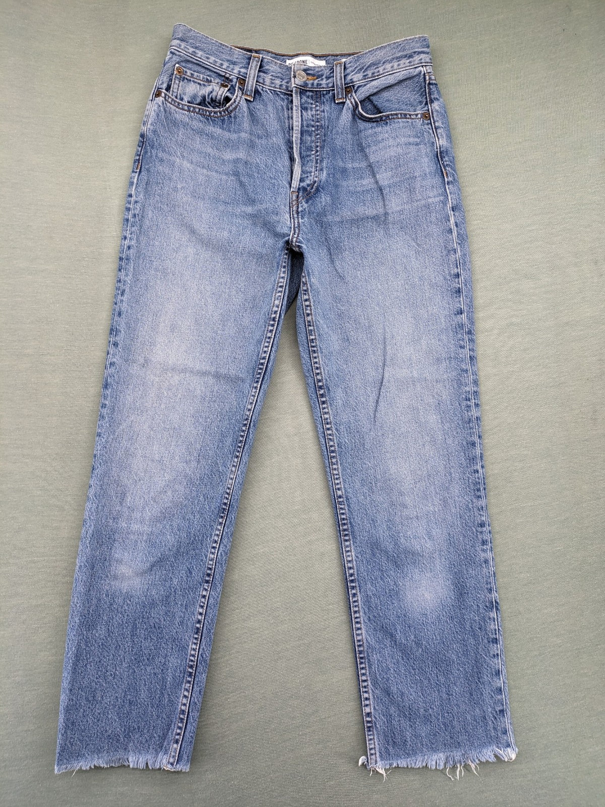 Re/Done blue straight jeans high rise with button fly and raw hem detail.