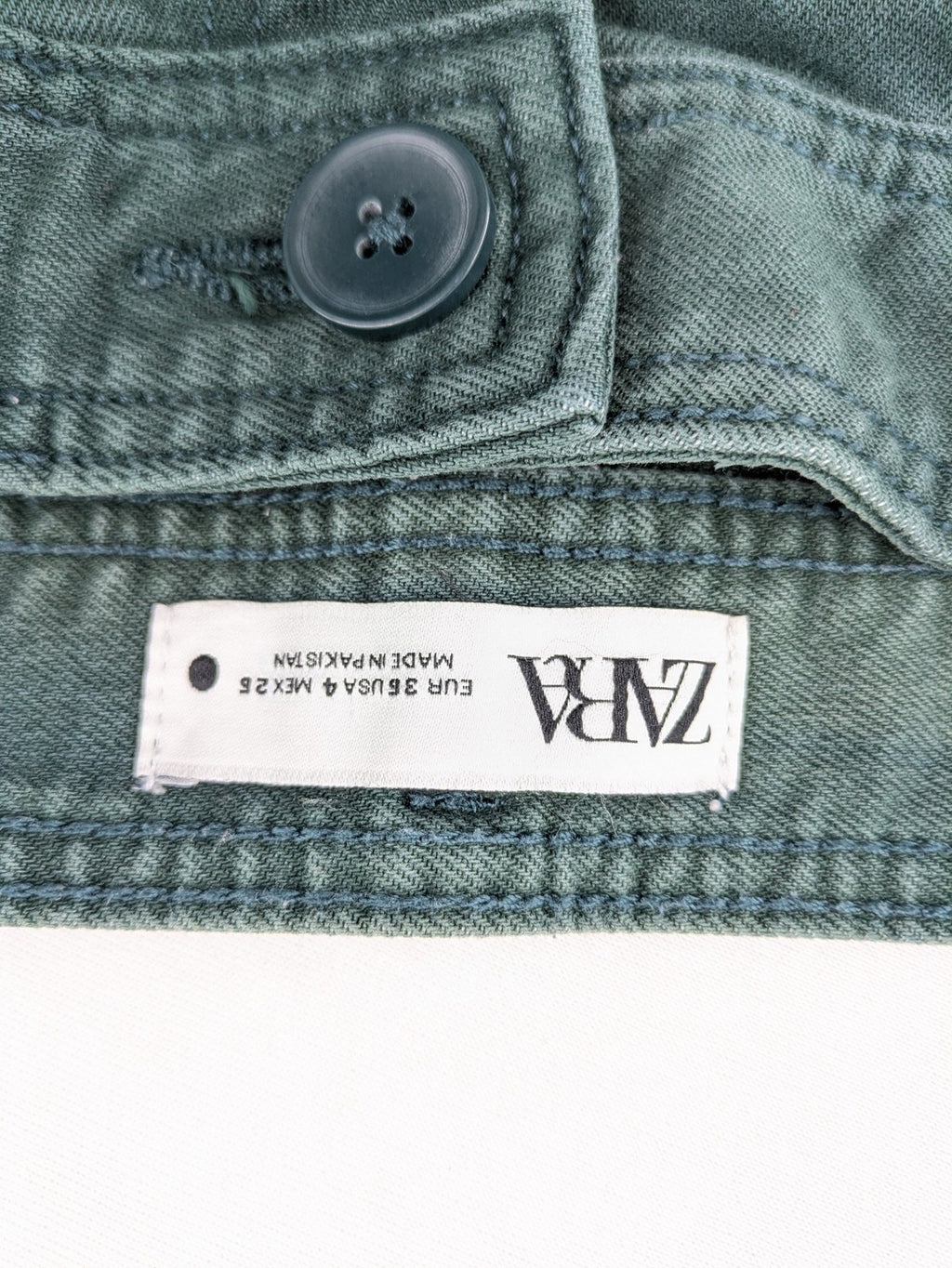 Zara green high waist wide leg jeans with frayed hem and button closure.