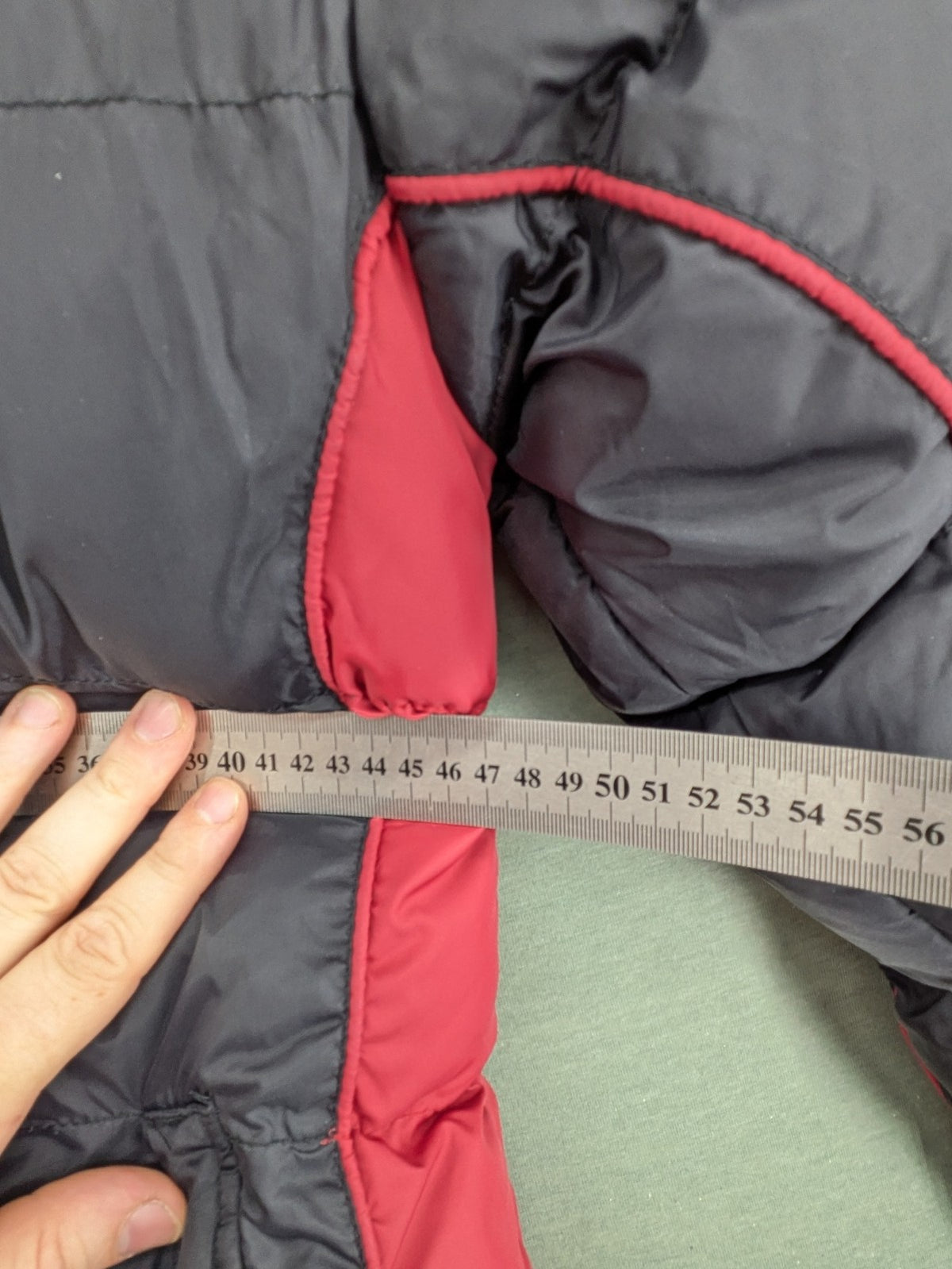 Puffer grey and red jacket with fleece lining, front zipper, and side pockets.