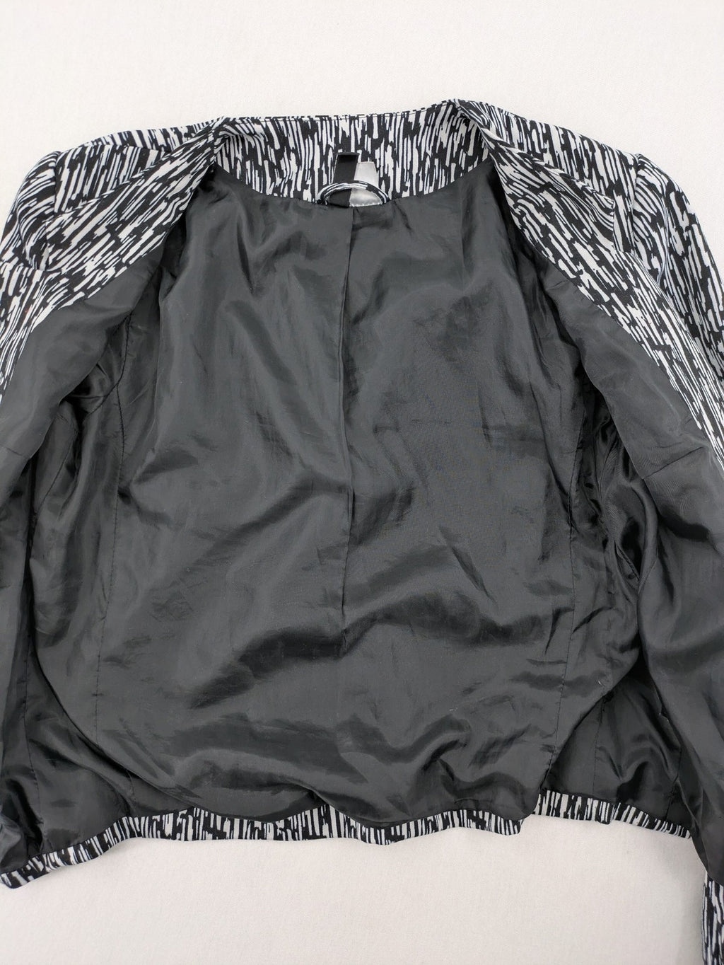 H&M Divided black and white patterned blazer with open front and two front pockets.