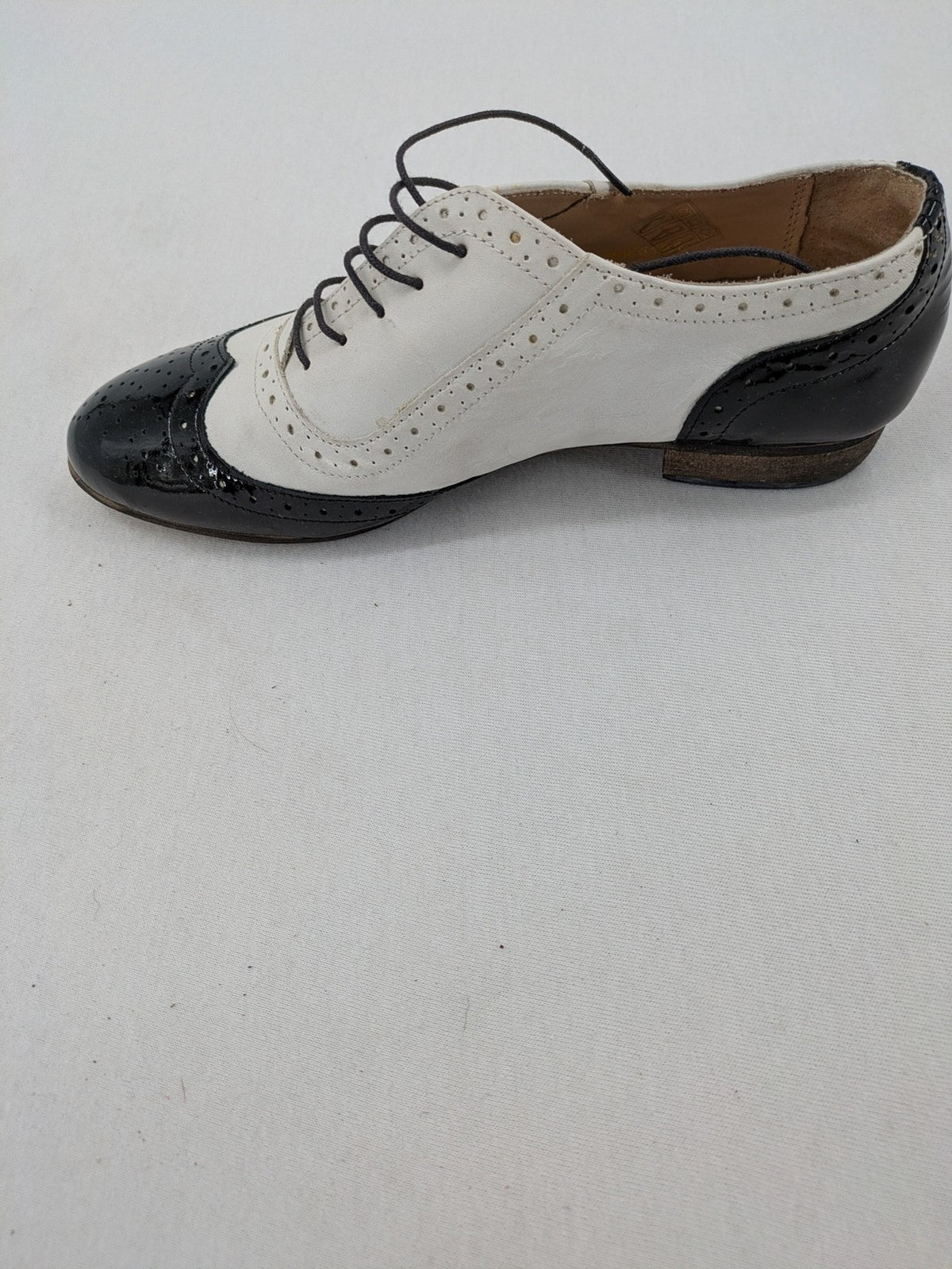 Kontrast black and white deck shoes, glossy patent leather with wingtip cap and brogue detailing.