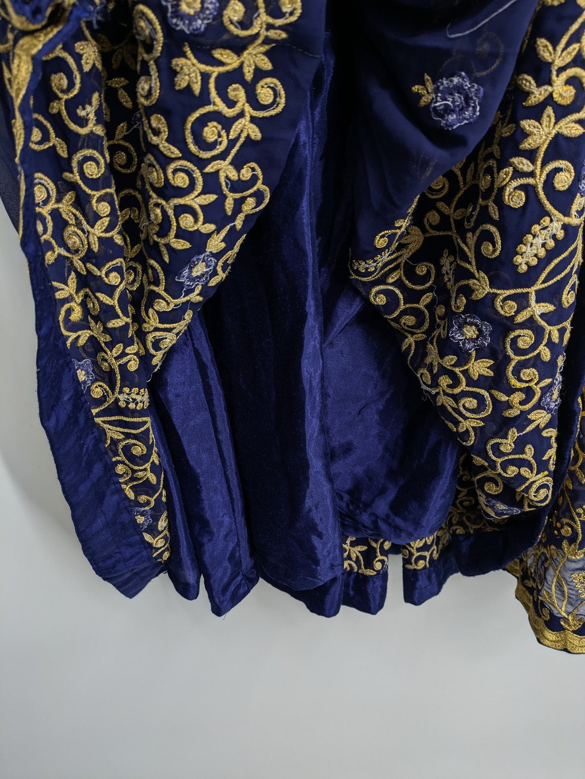 Bollywood bridal party dress gold with intricate blue embroidery and flowing Anarkali silhouette.