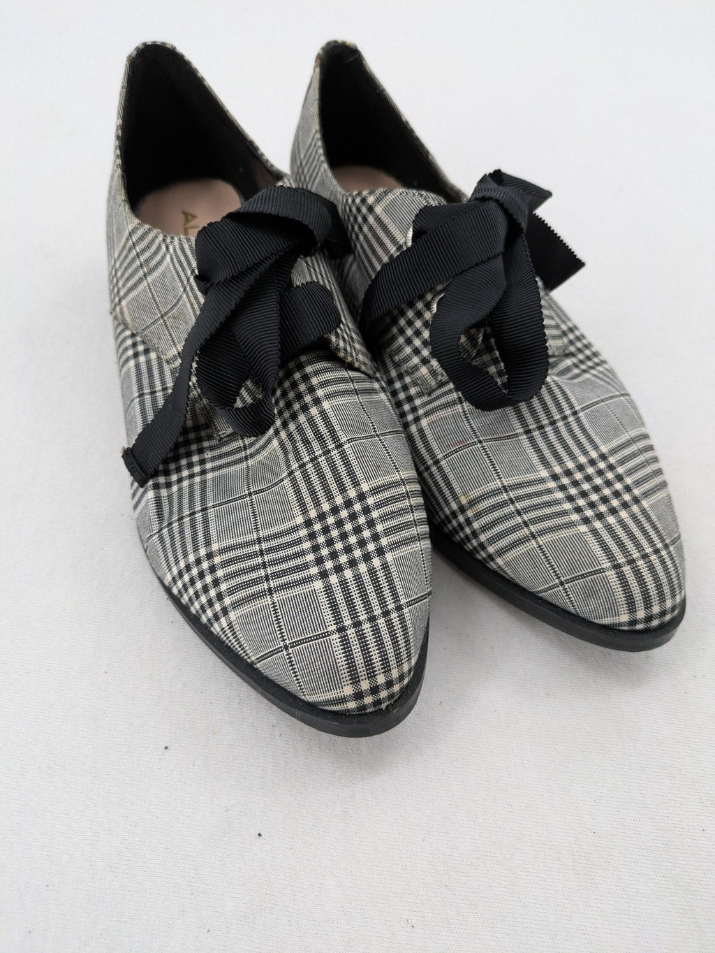 ALDO black and white checkered loafers with decorative bow detail and pointed toe.