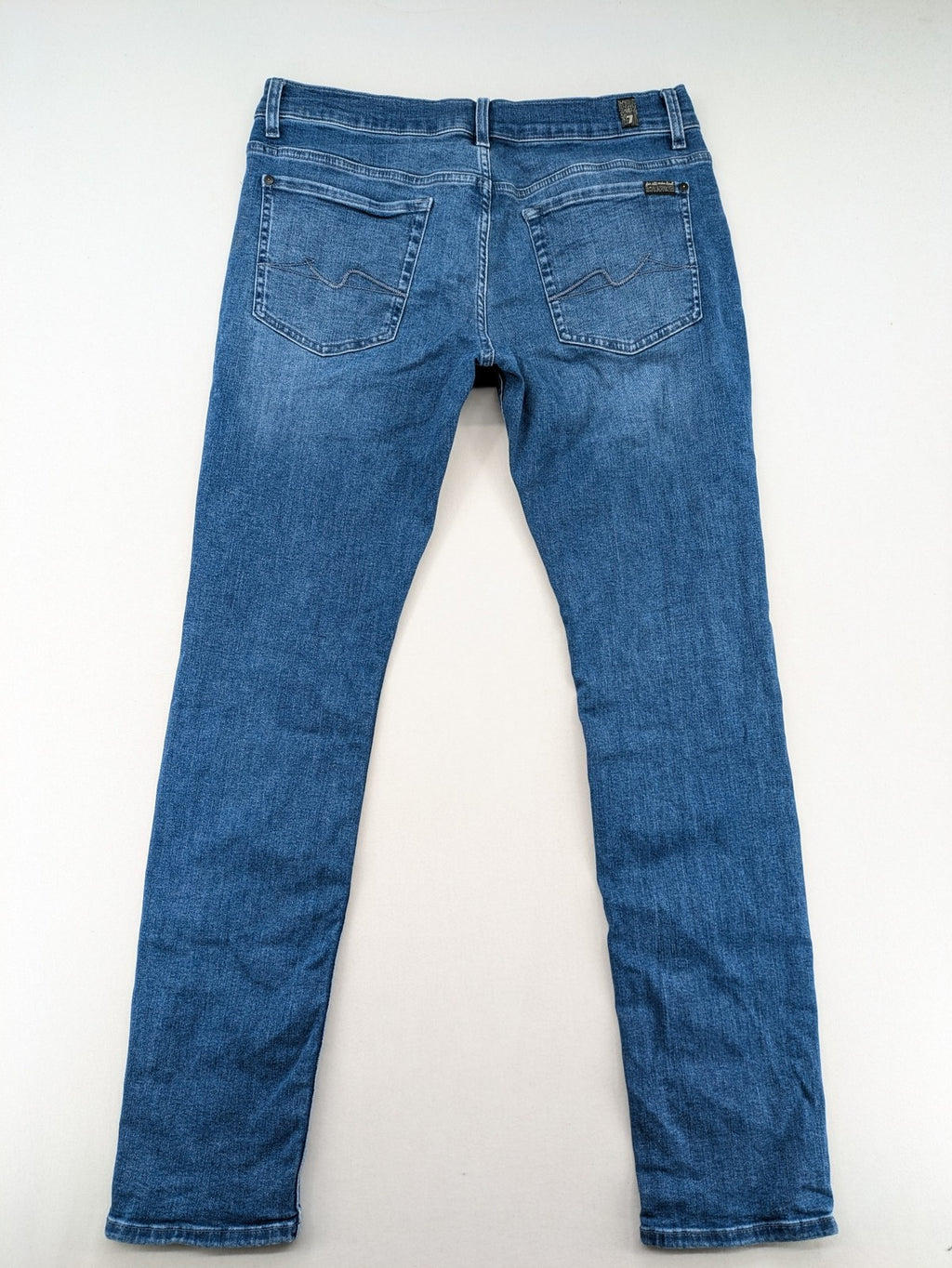 7 For All Mankind blue straight jeans with 5-pocket design and logo on back pocket.