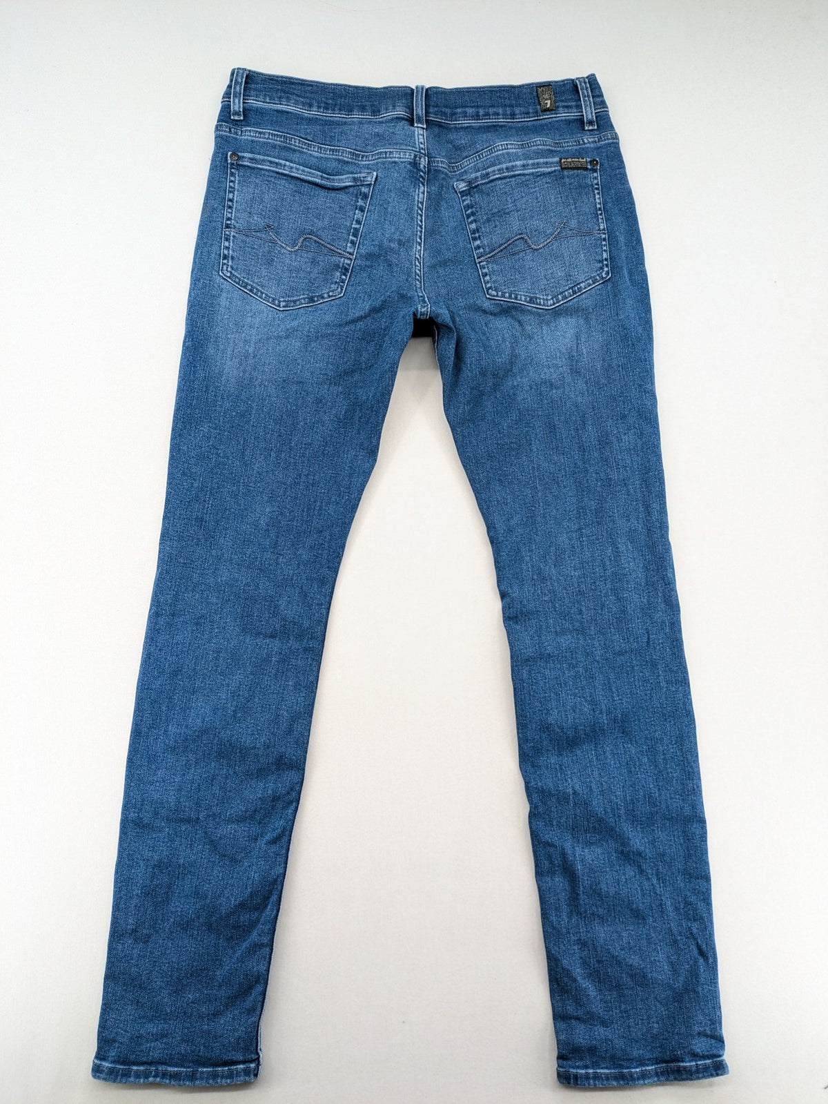 7 For All Mankind blue straight jeans with 5-pocket design and logo on back pocket.