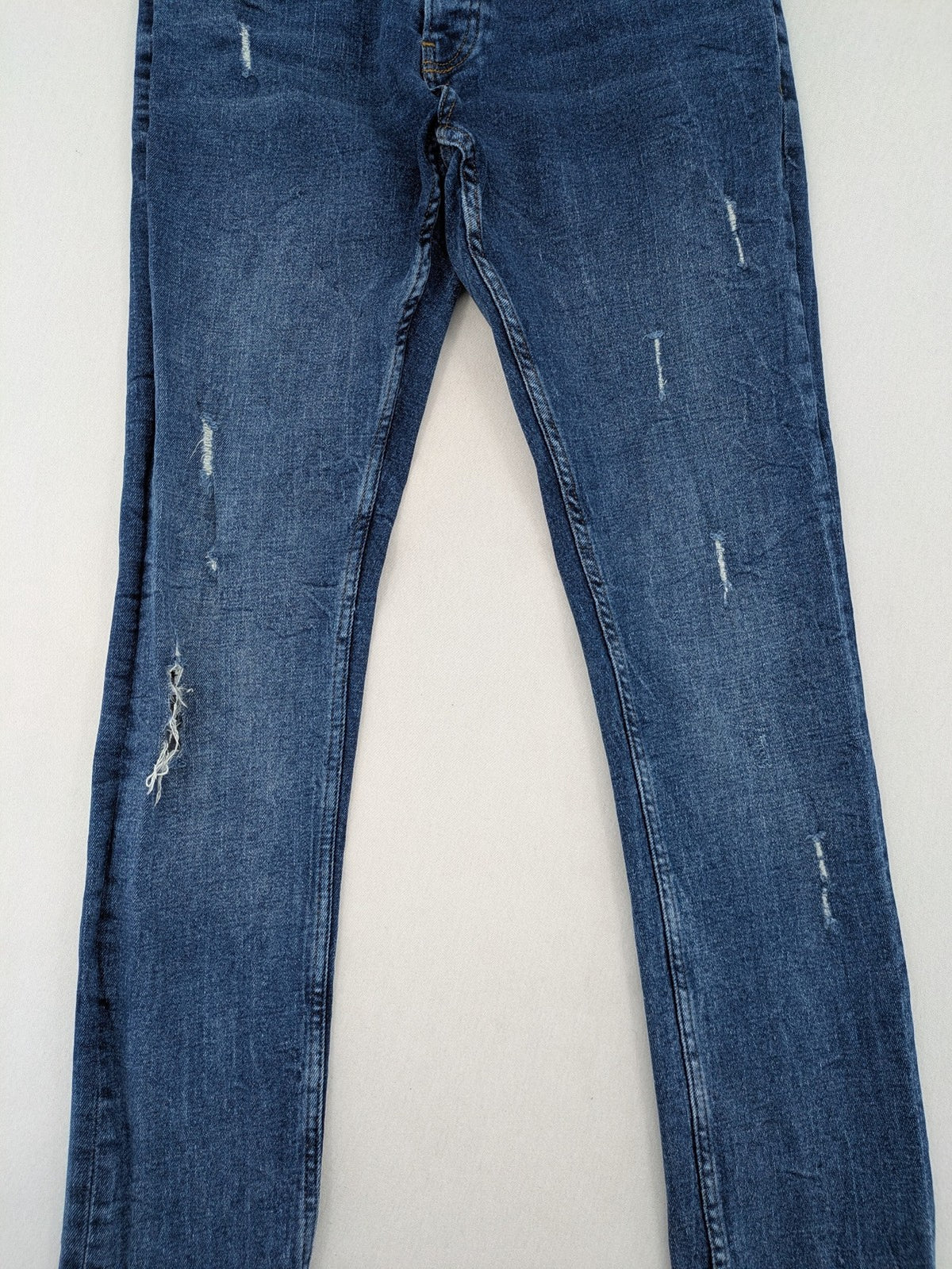 2Y Premium blue skinny jeans with distressed details and classic button fly.