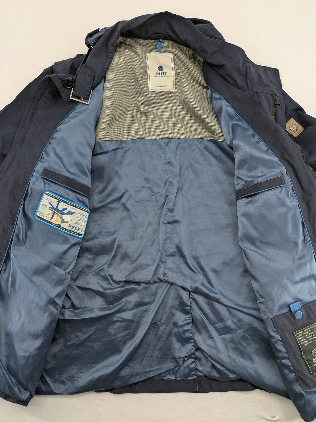 Reset navy parka jacket windproof with adjustable hood and zippered chest pocket.
