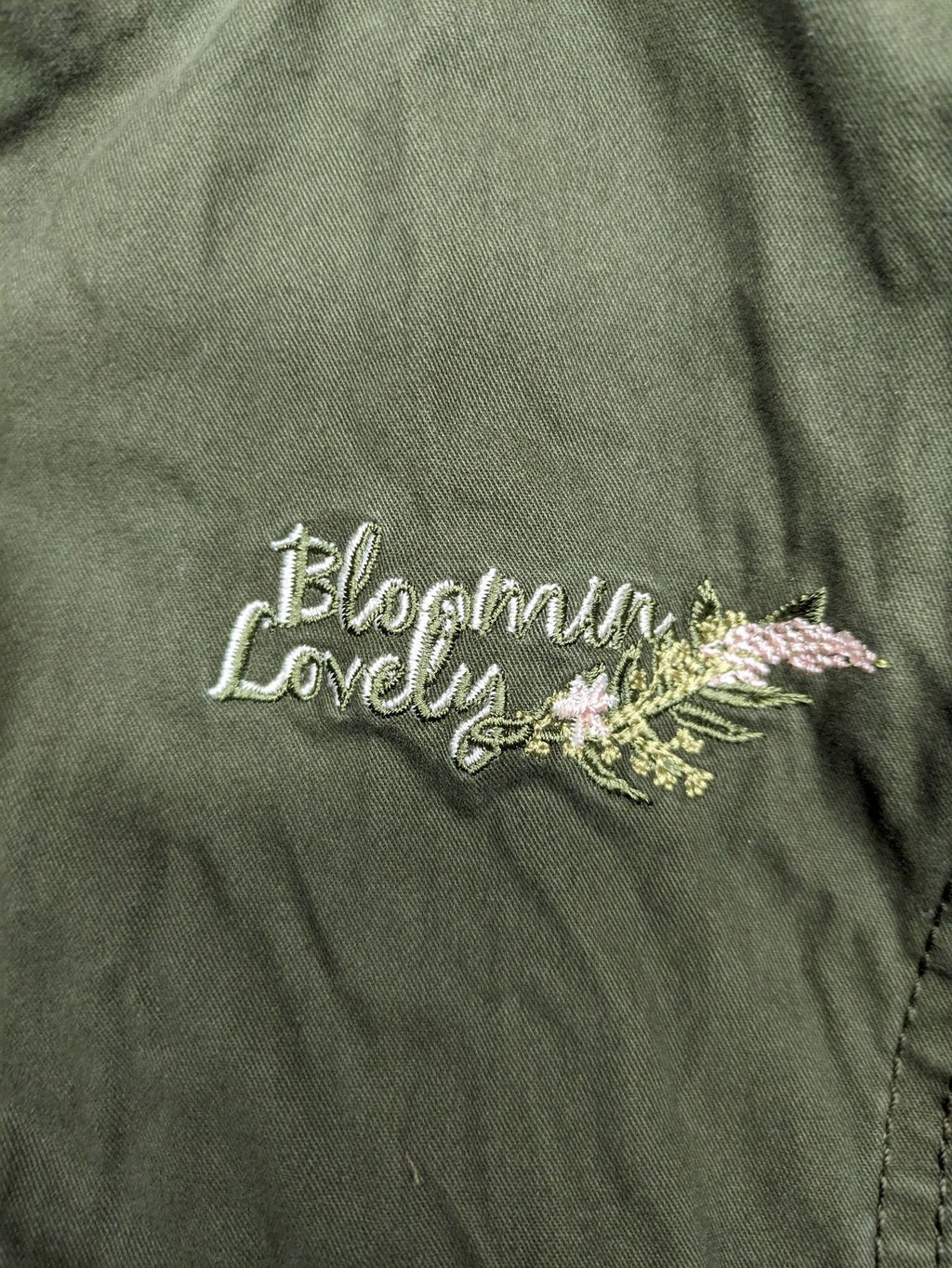 Vp Fashion khaki parka coat with "Bloomin' Lovely" floral embroidery and quilted lining.