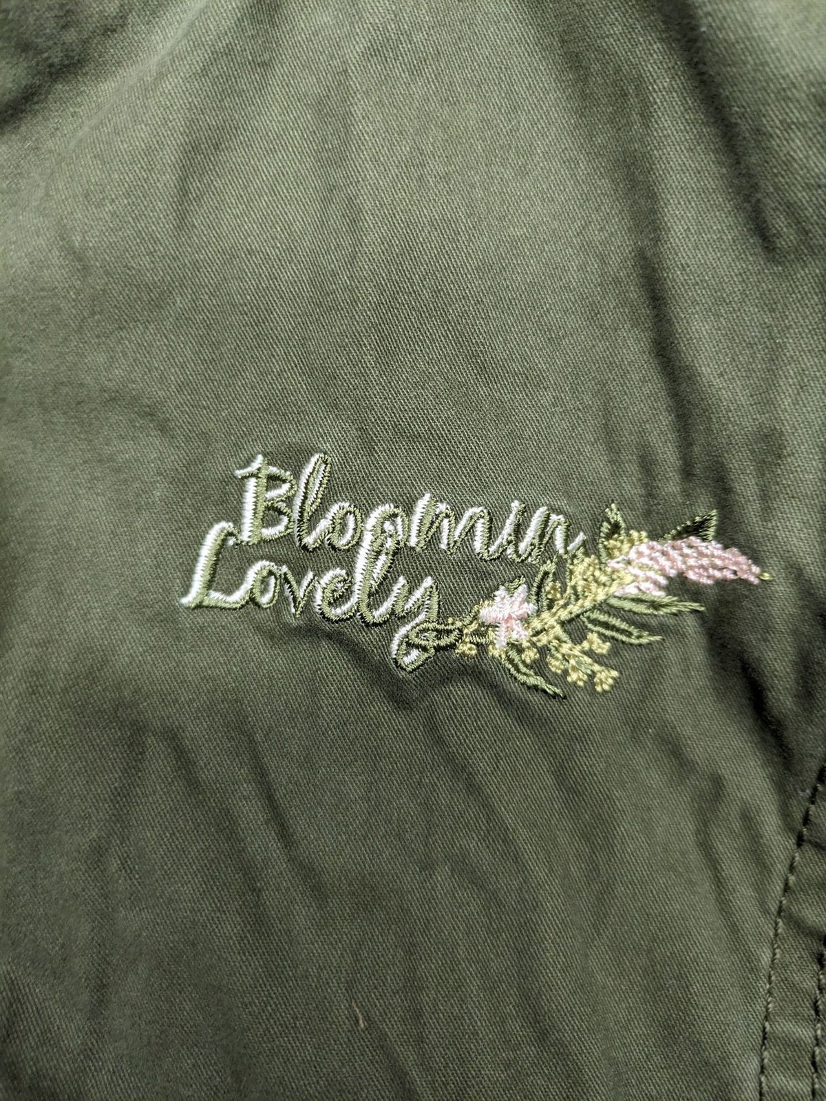 Vp Fashion khaki parka coat with "Bloomin' Lovely" floral embroidery and quilted lining.