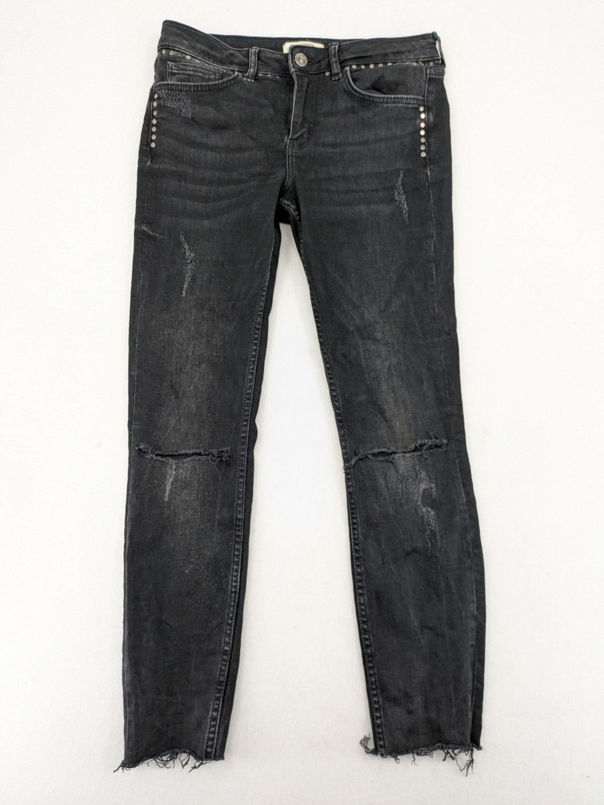 Zara Woman black skinny jeans with distressed details, silver studs, and frayed hem.