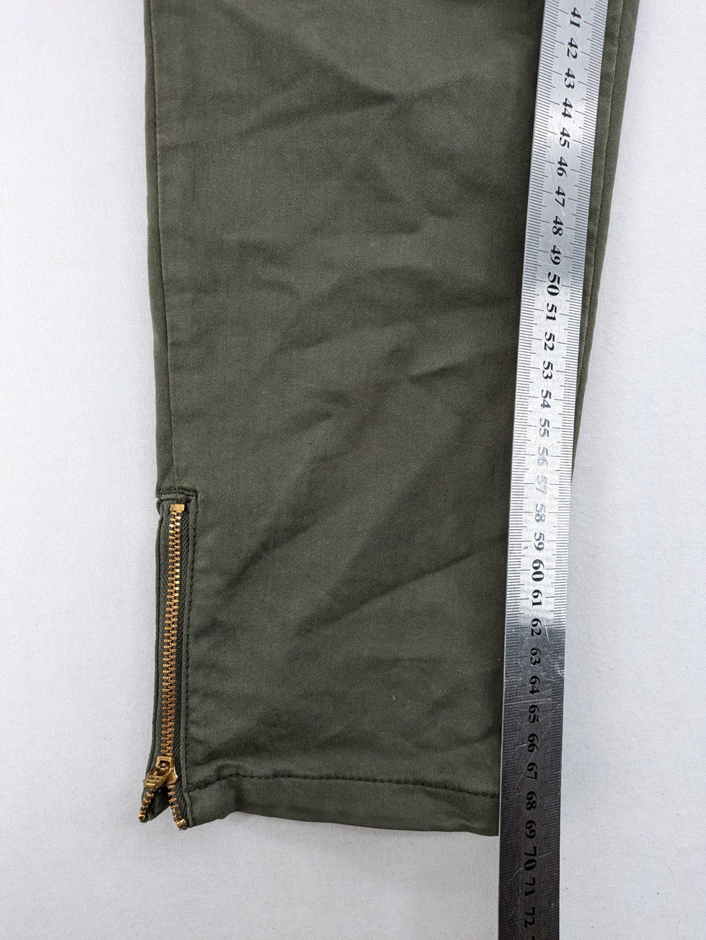 Maison 123 green cargo pants with ankle zippers and gold metal details.