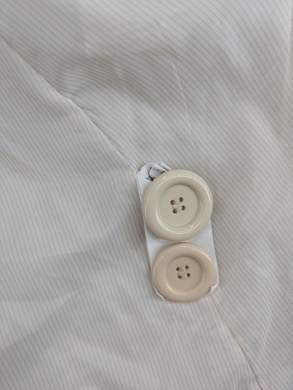 H&M beige trench coat size 38, classic design with button closure and striped lining.