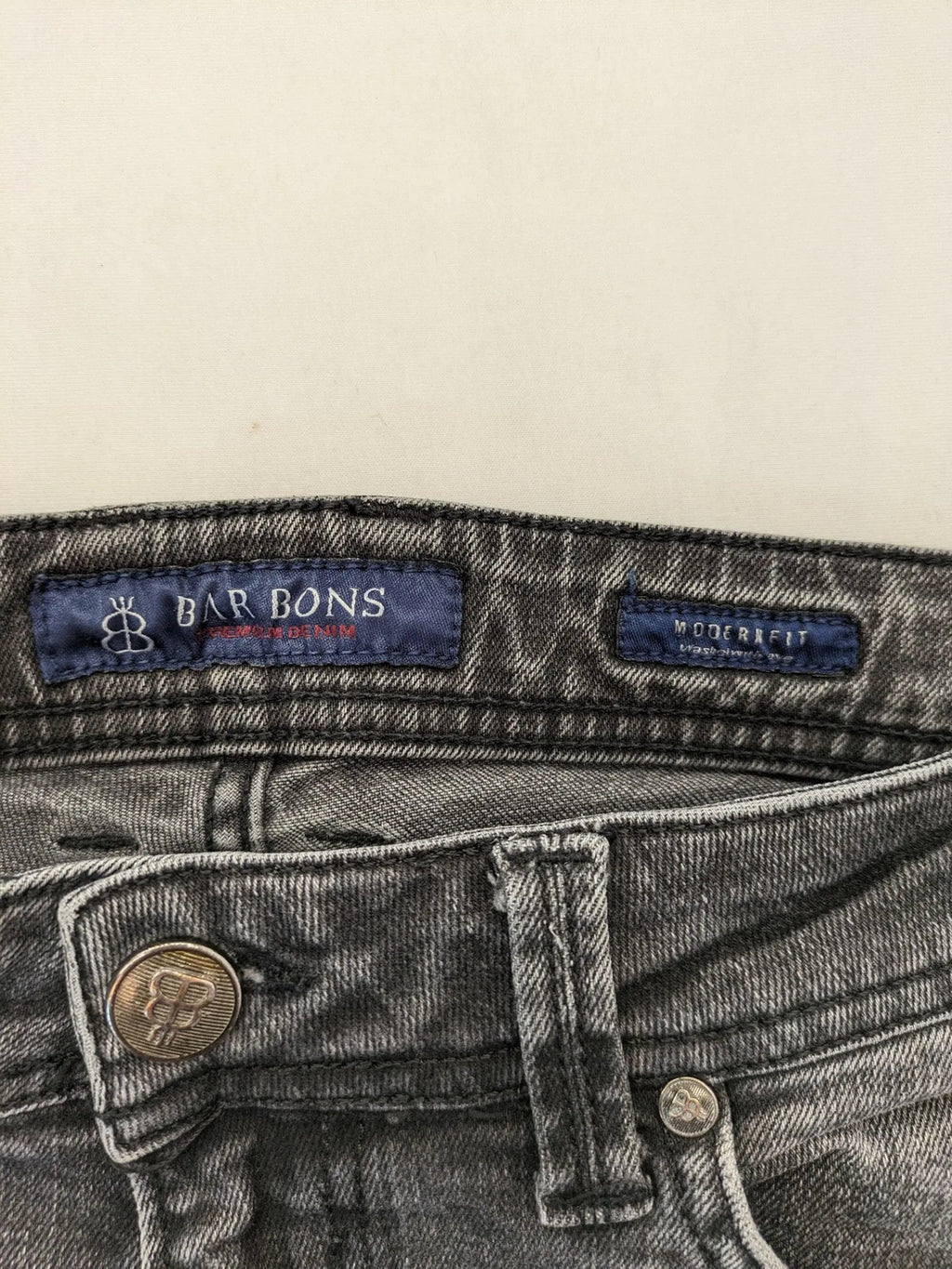 Denim grey straight jeans 5-pocket design with subtle brand details and zipper closure.