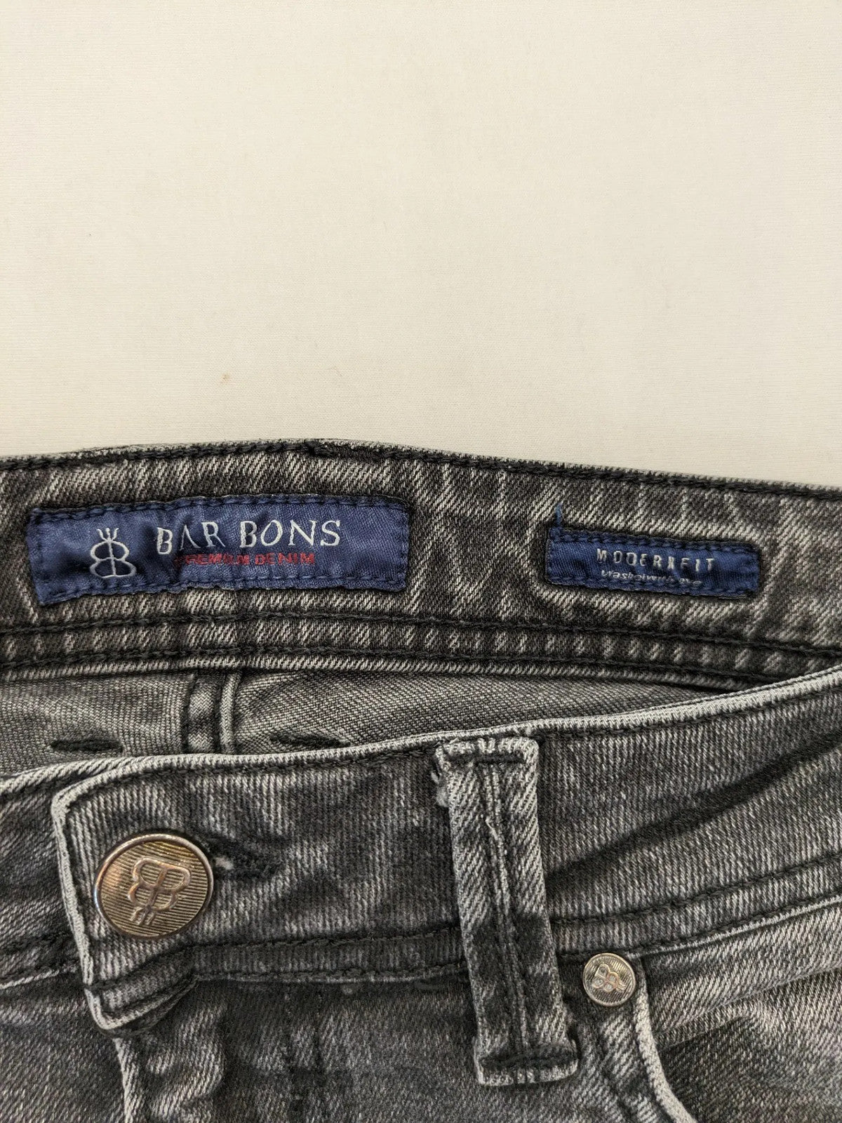 Denim grey straight jeans 5-pocket design with subtle brand details and zipper closure.